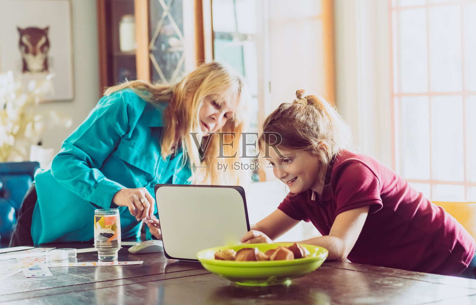 奶奶和小学的孩子在一个家庭餐厅里用电脑照片摄影图片