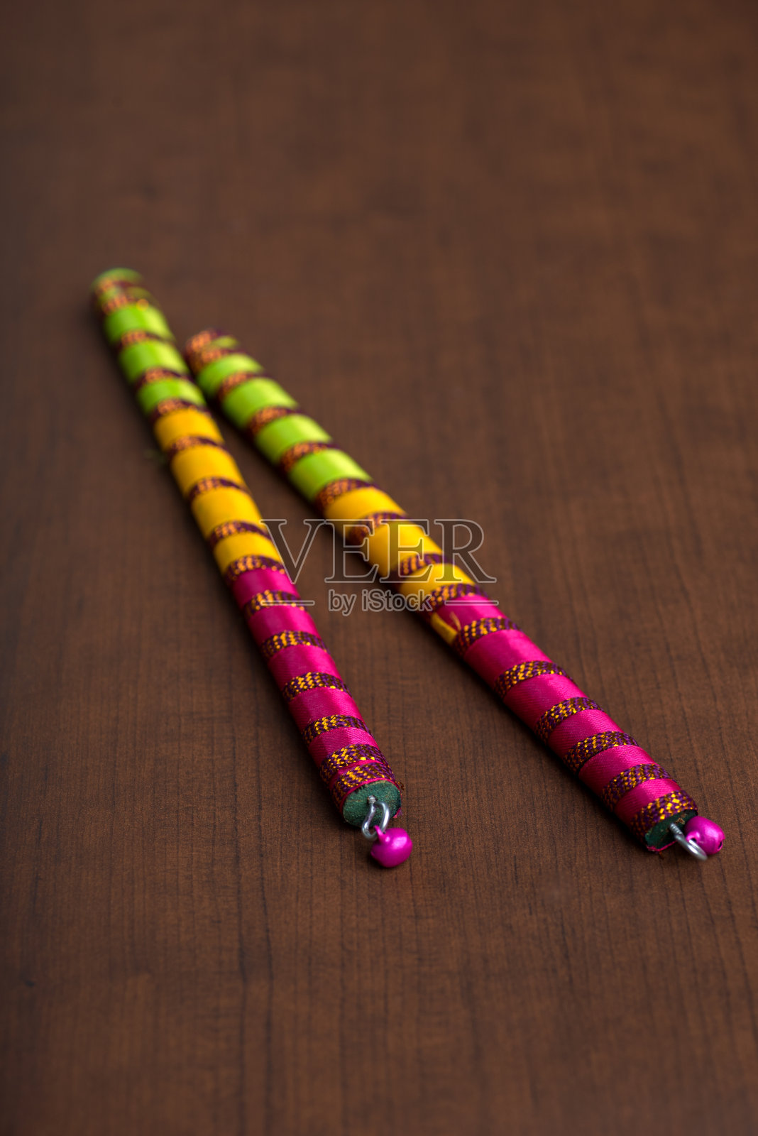 丹迪亚的背景是棕色的。Raas Garba或Dandiya Raas是印度古吉拉特邦和拉贾斯坦邦的传统民间舞蹈。照片摄影图片