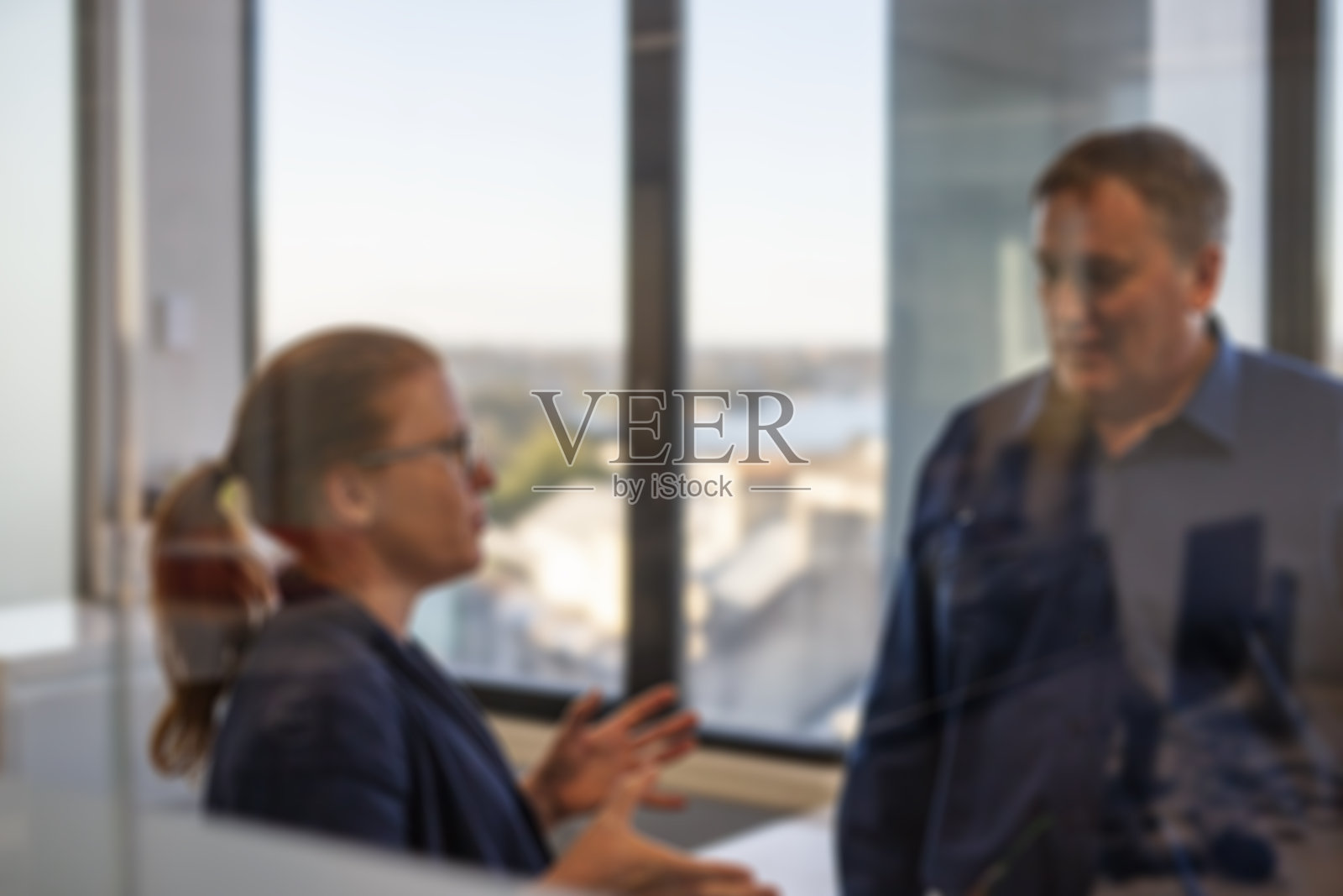 在办公室里站着说话的商业男人和女人照片摄影图片