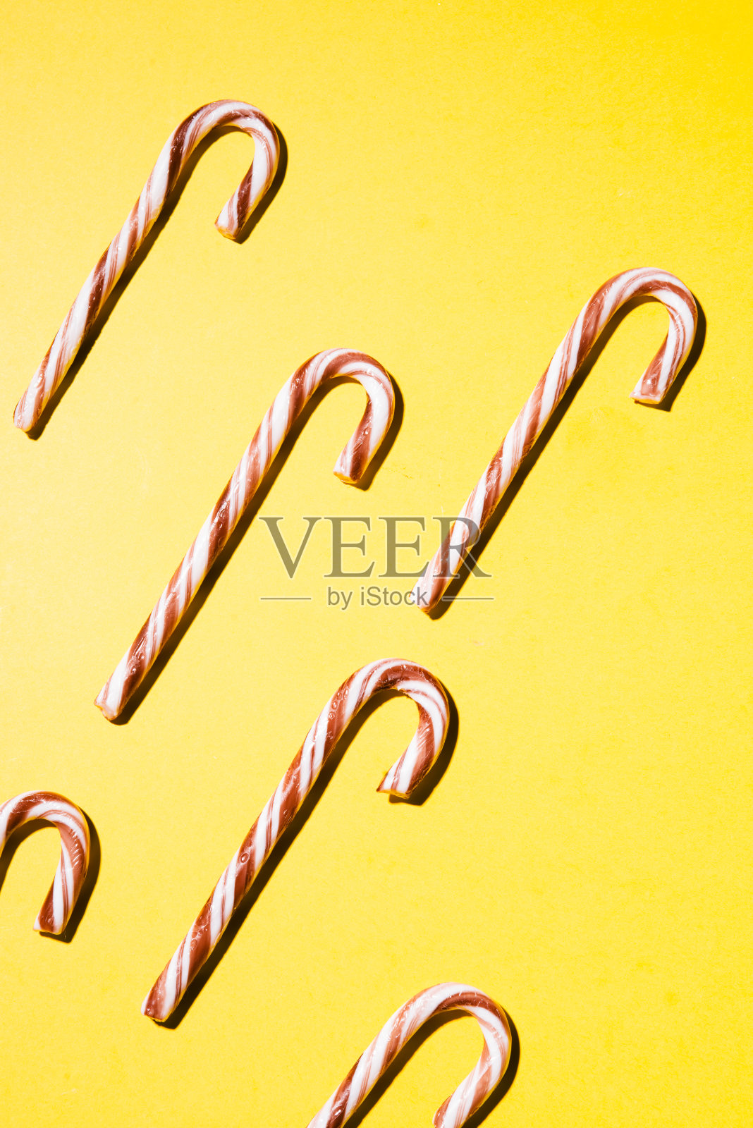 黄色背景上的拐杖糖照片摄影图片