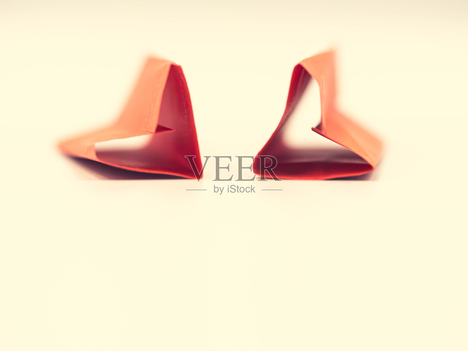 穿越过程的基调。特写折叠纸生动或充满活力的红色心形在柔和的黄色背景。情人节，婚礼，爱情，甜蜜和浪漫的概念和想法。照片摄影图片