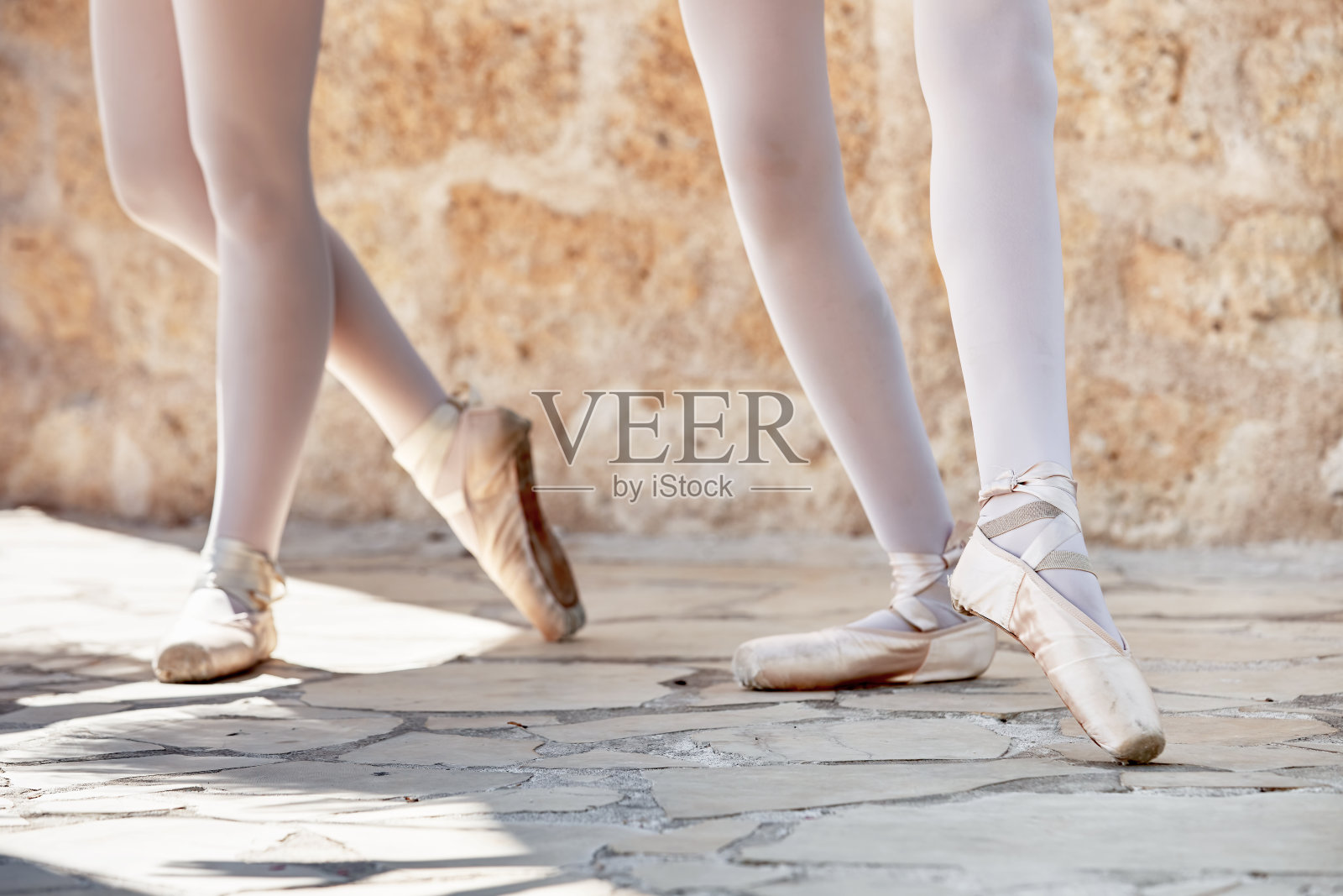 穿着粉色尖头鞋的芭蕾舞者的腿，在排练他们的位置照片摄影图片