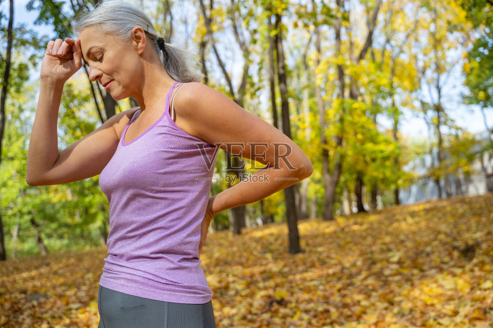 一个闭着眼睛站在公园里的女人照片摄影图片
