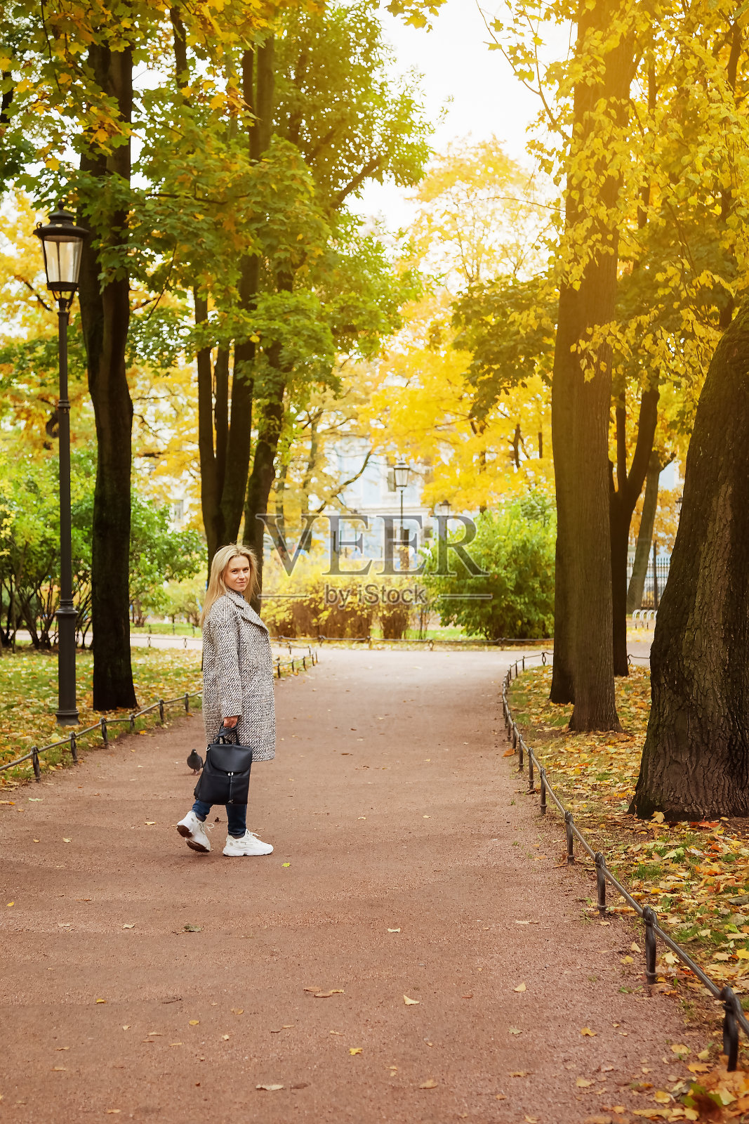 一个年轻女子在秋天走在巷子里的肖像照片摄影图片