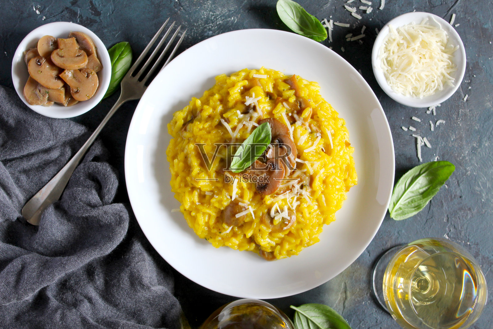 传统的意大利调味饭配蘑菇，藏红花和帕尔马干酪，配白葡萄酒。照片摄影图片
