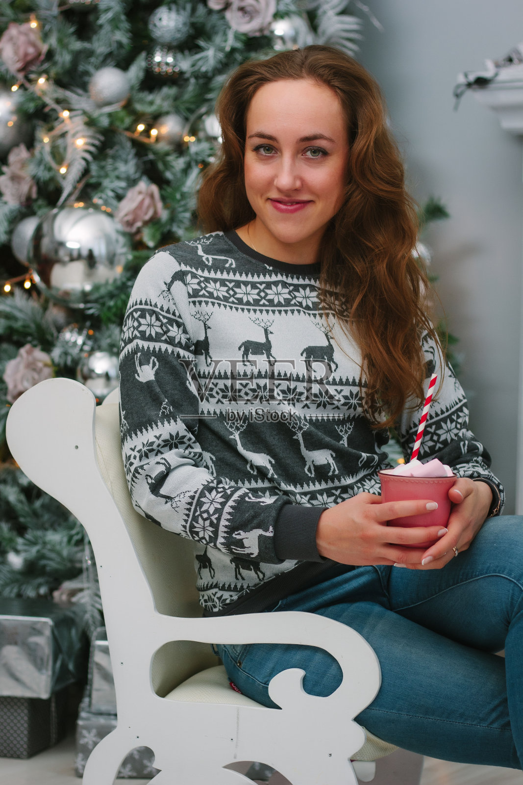 美丽的女孩与棉花糖在圣诞树附近的肖像。照片摄影图片