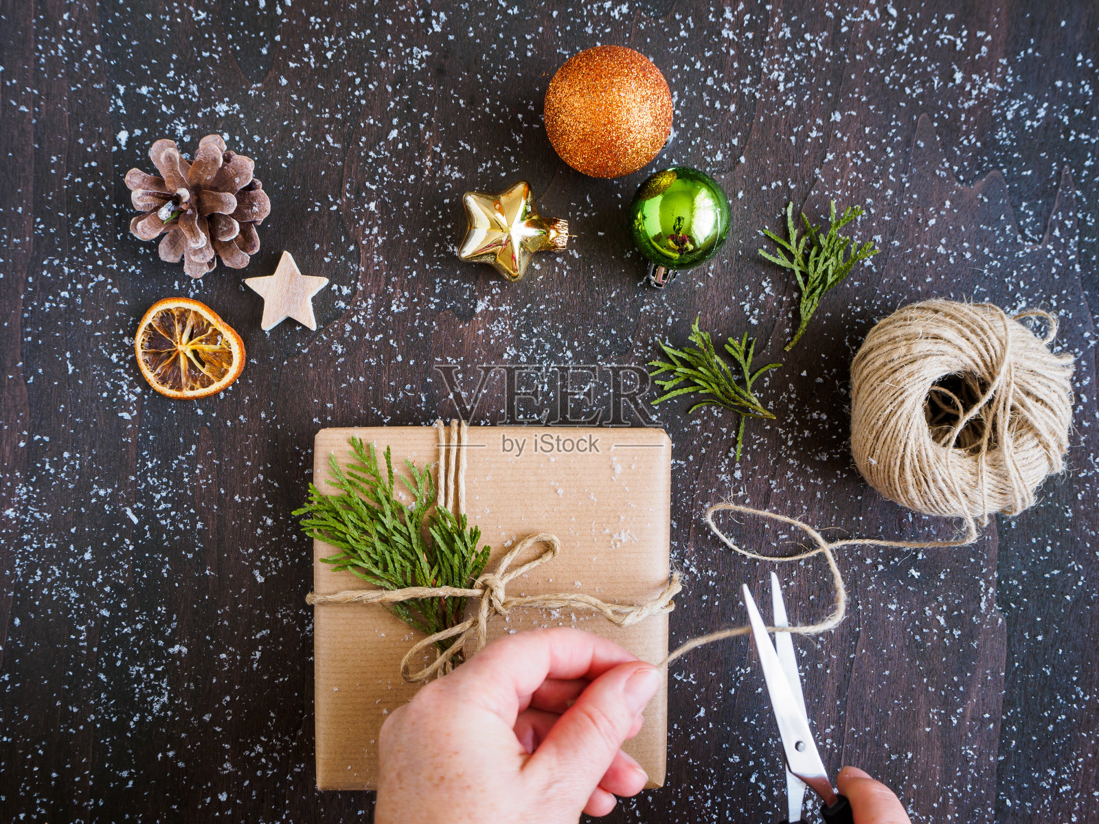手用剪刀和礼物和圣诞装饰在一个灰色的背景照片摄影图片