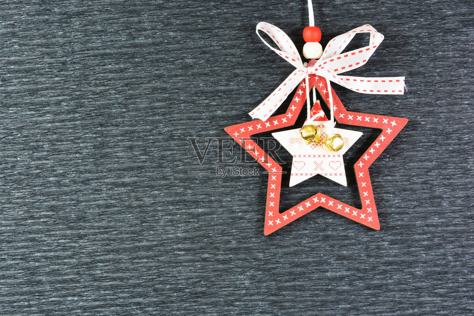 圣诞美丽的贺卡。圣诞树的木制装饰，在黑色的背景上有一个带蝴蝶结的星星形状照片摄影图片