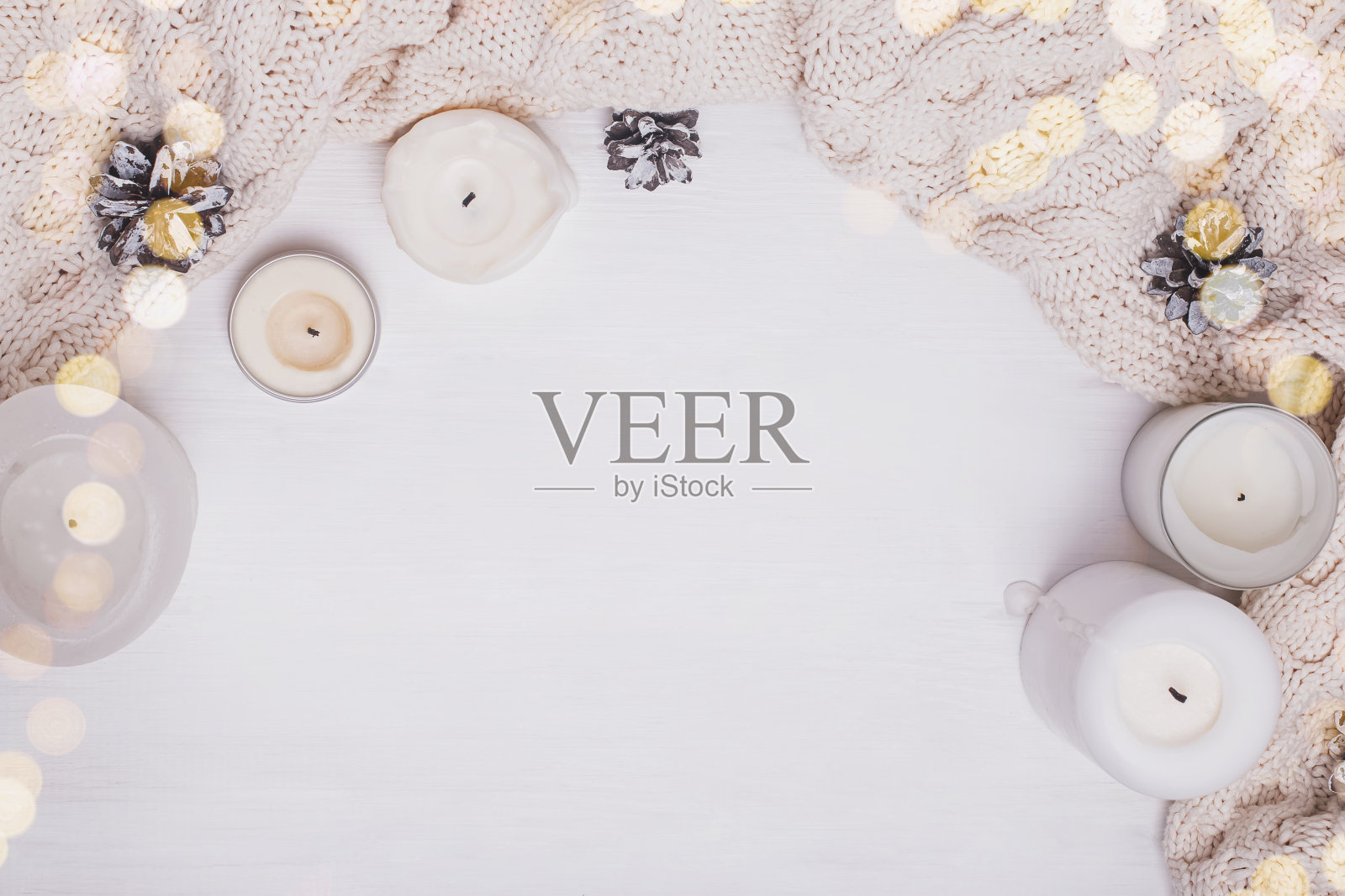 白色蜡烛，针织毛衣和松果在白色背景，俯视图。照片摄影图片