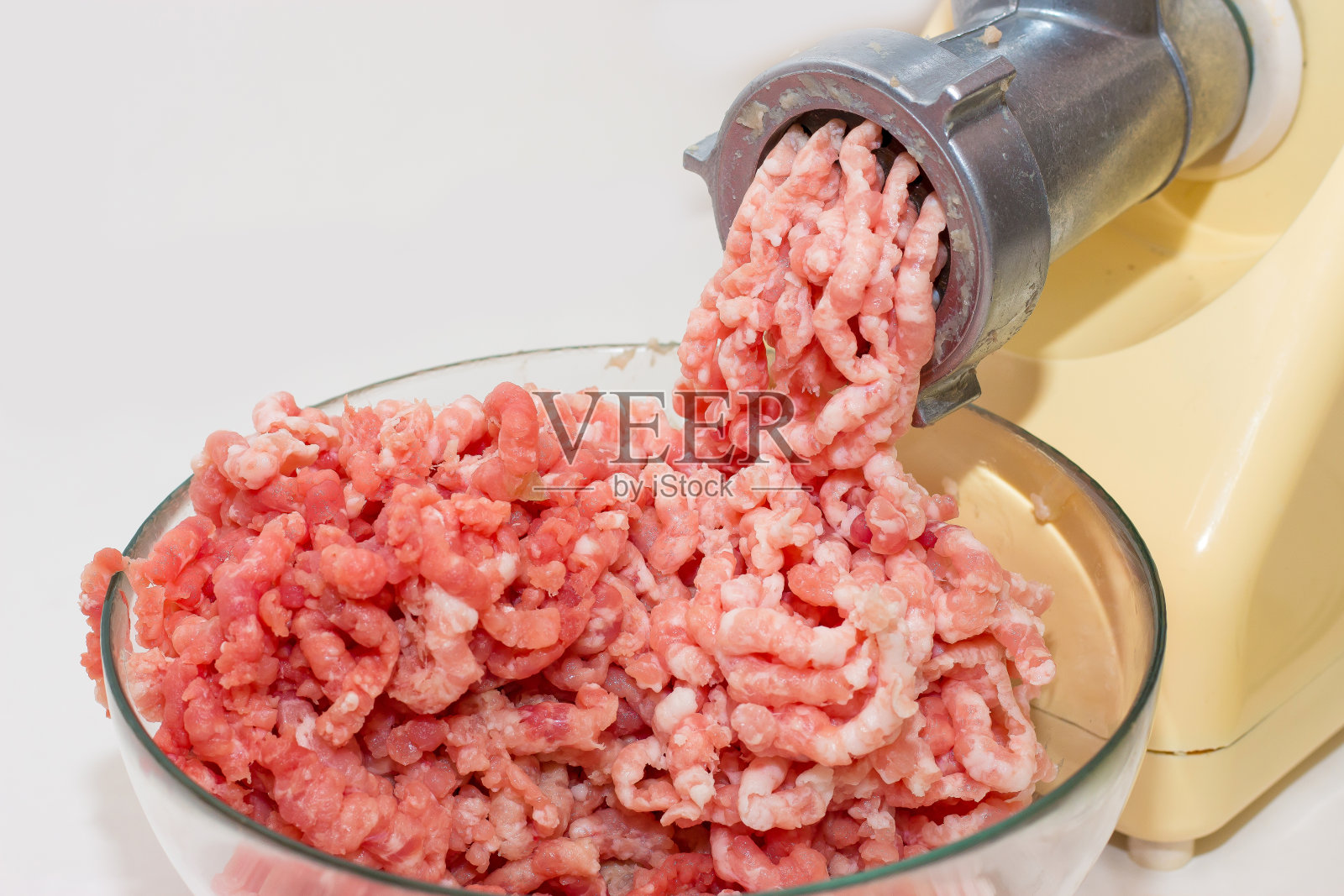 在家做碎肉。绞肉机与新鲜的肉末。照片摄影图片