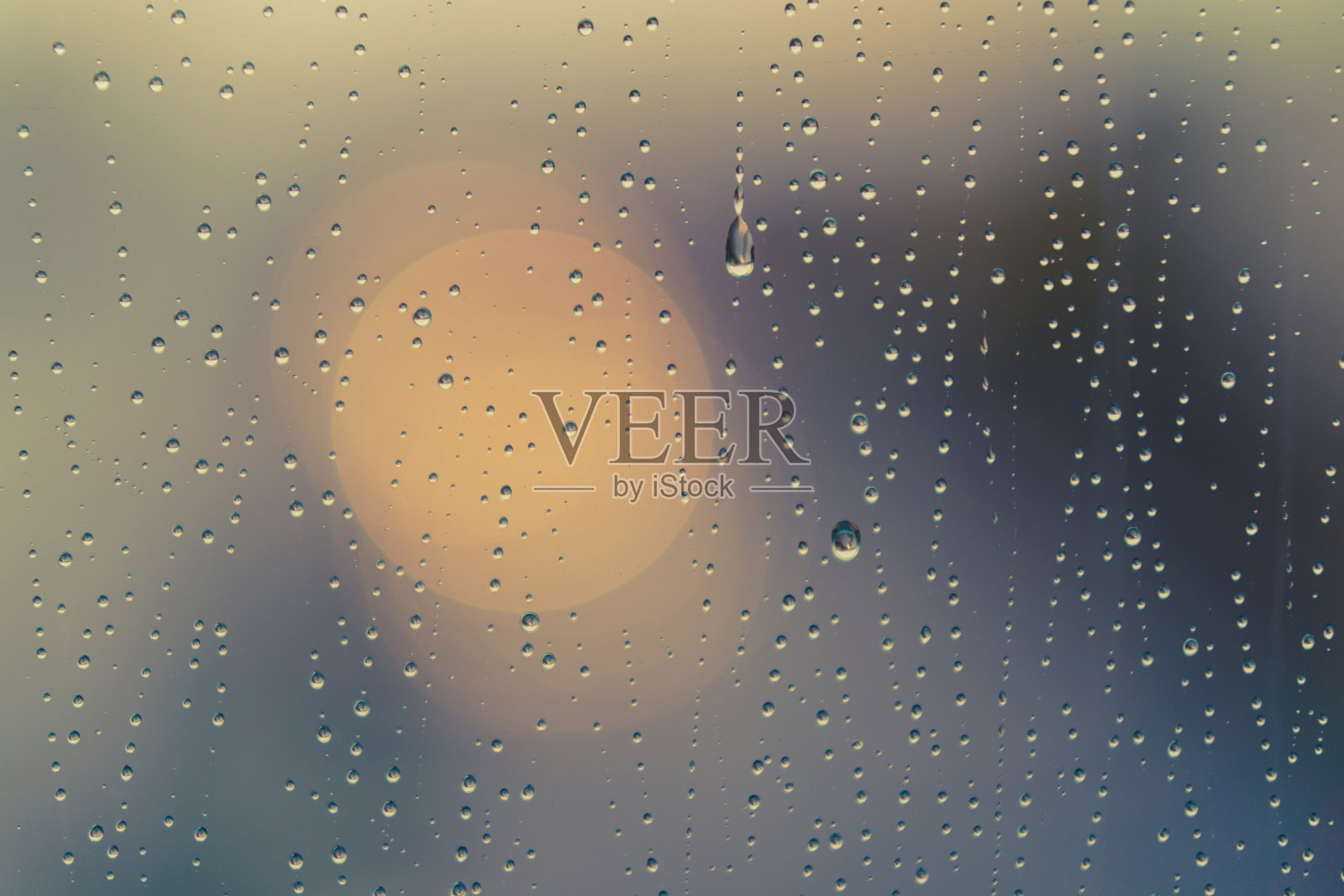 散焦摄影城市街道透过玻璃窗和雨滴落在窗户玻璃上照片摄影图片