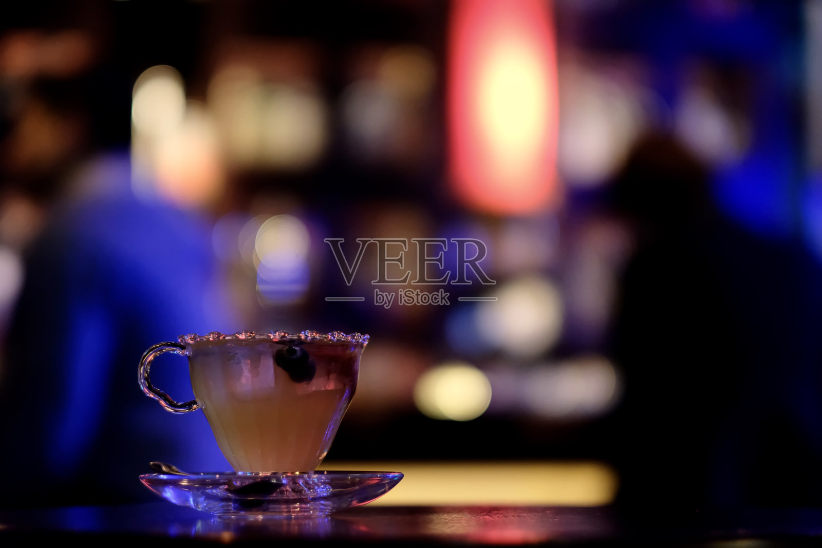 靠近一杯水果鸡尾酒在吧台上。照片摄影图片