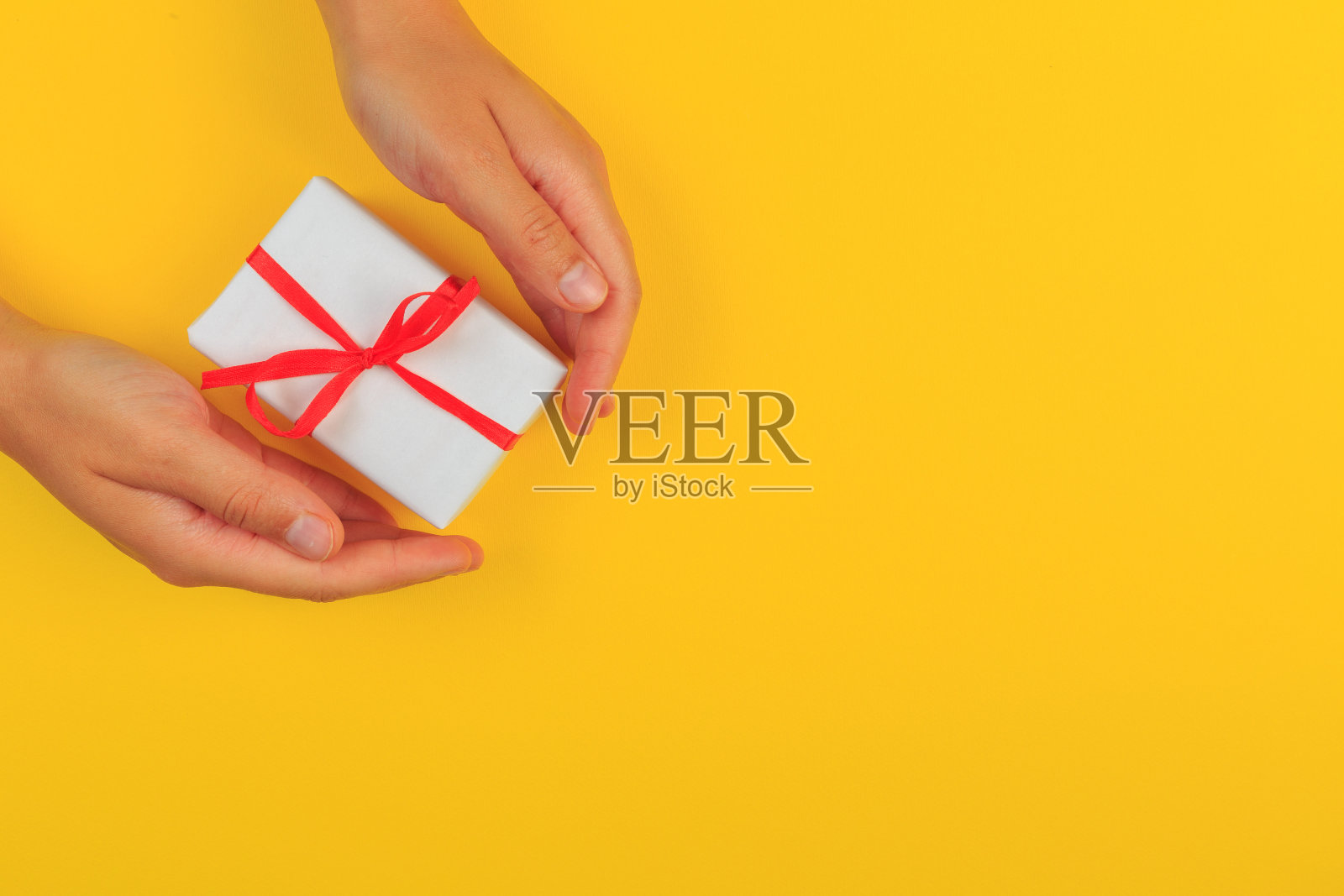 礼物在女性手中的彩色背景俯视图。照片摄影图片