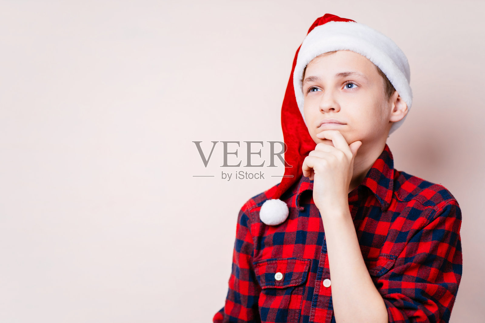 戴着圣诞帽沉思的男孩在想着什么照片摄影图片