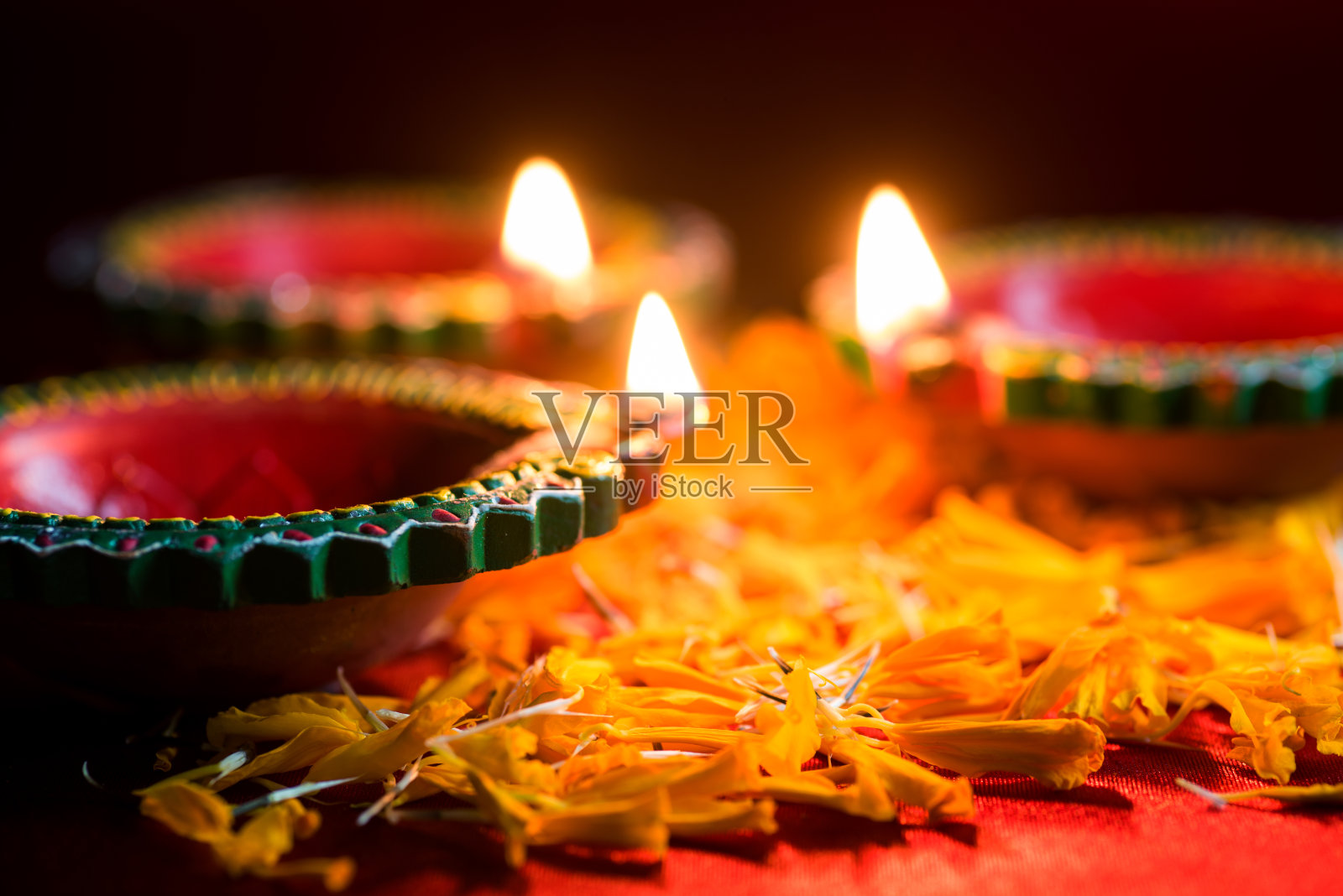 快乐的排灯节-粘土Diya灯点燃在排灯节庆祝。印度排灯节的问候卡设计照片摄影图片