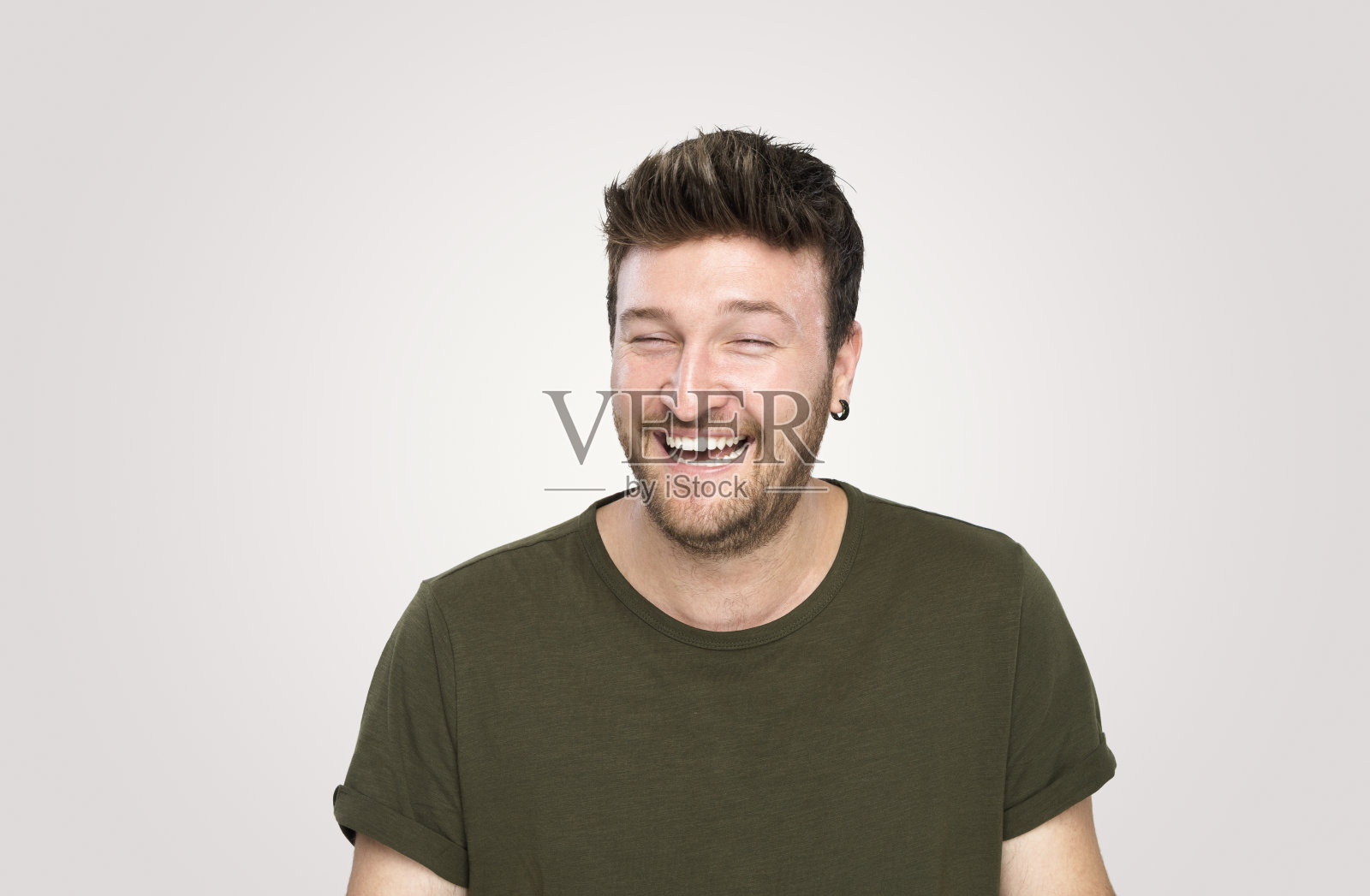 在灰色背景上开怀大笑的英俊青年照片摄影图片