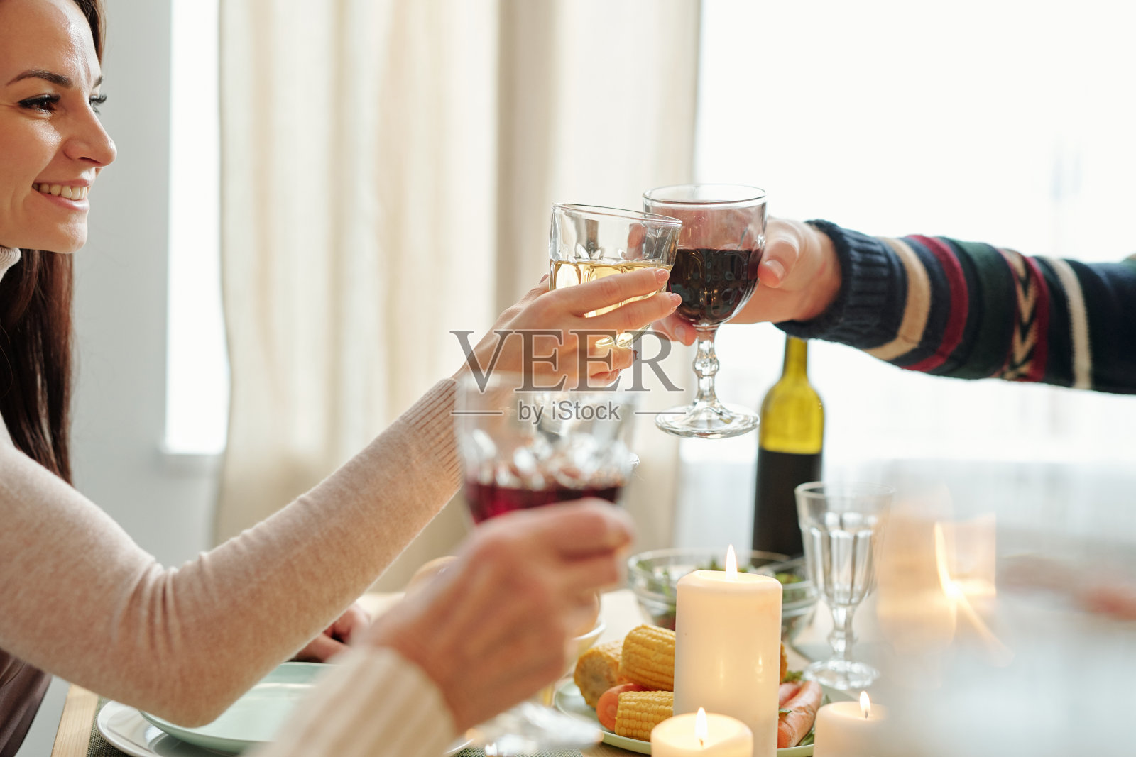 快乐的年轻女子和她的父亲在桌子上碰杯喝酒照片摄影图片