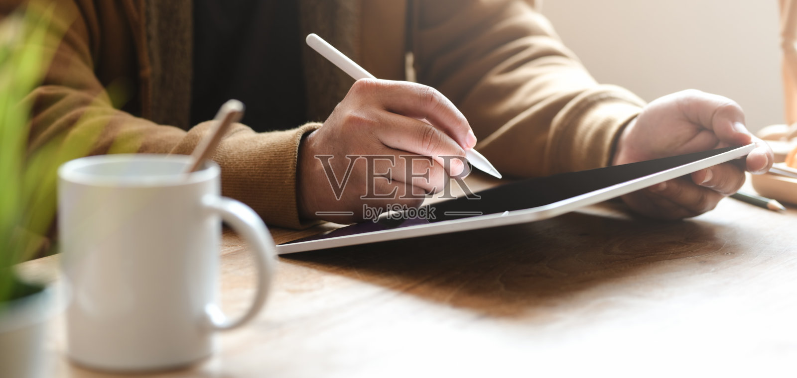 在他舒适的办公室里使用平板电脑的人在他的项目上工作的特写视图照片摄影图片