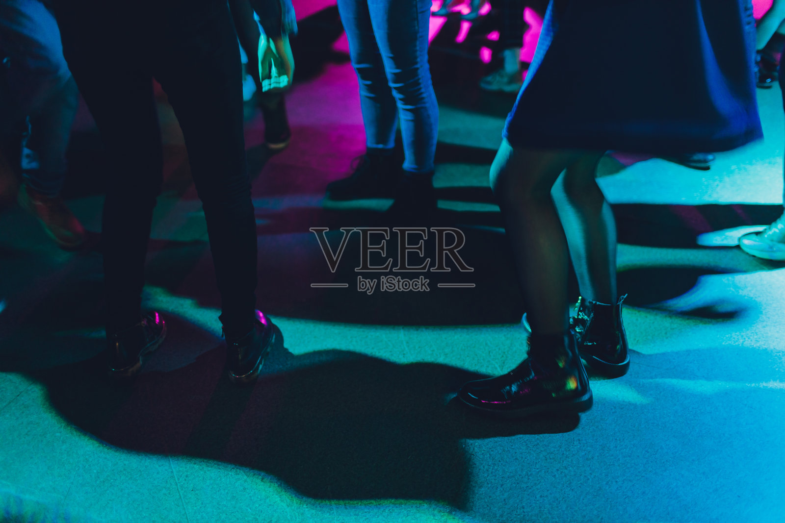 在俱乐部聚会上跳舞的人的脚。认不出来。照片摄影图片
