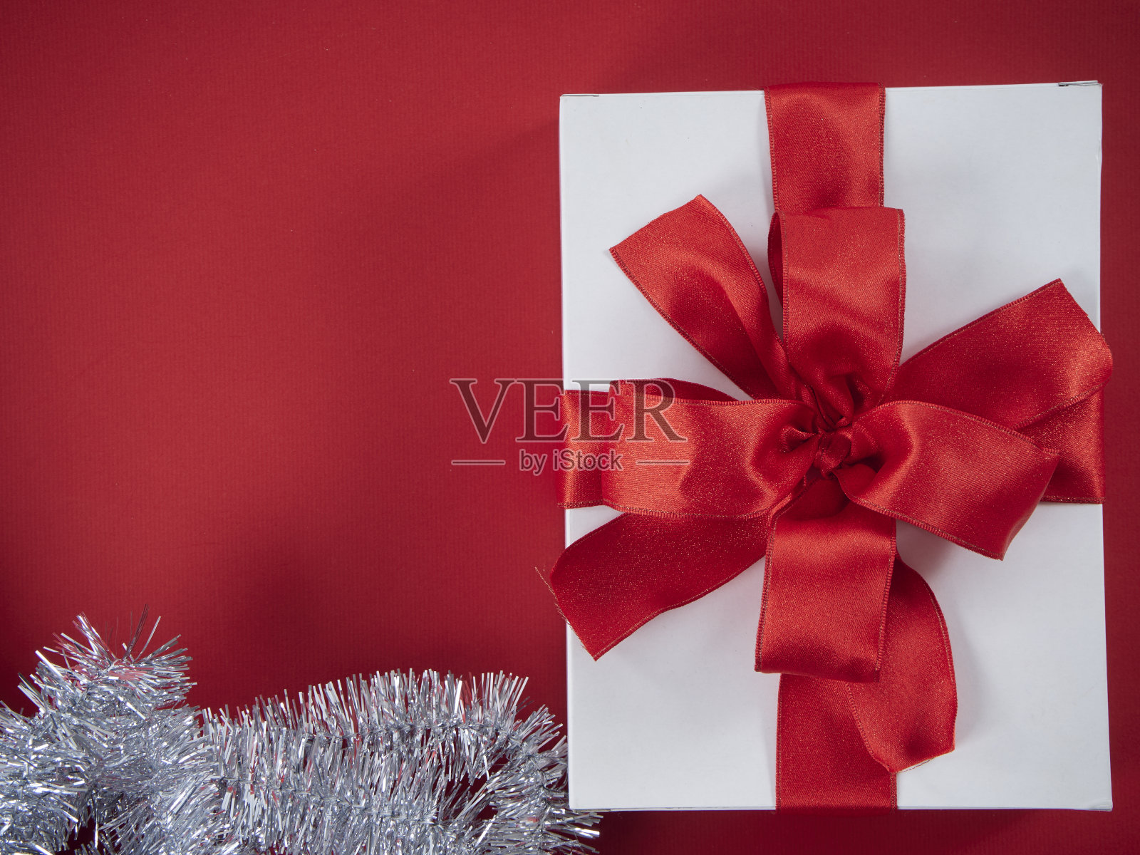 用圣诞贺卡和新年贺卡组成节日装饰。红色背景的礼品盒。照片摄影图片