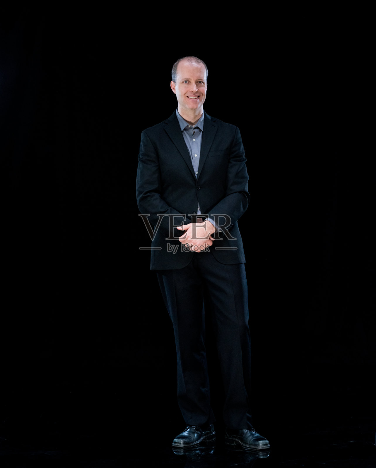 全身/一人/一人/正面视图/看着照相机的成年人英俊的人白人男性/年轻男子经理/商人/商人站在黑色背景穿着西装/黑色照片摄影图片
