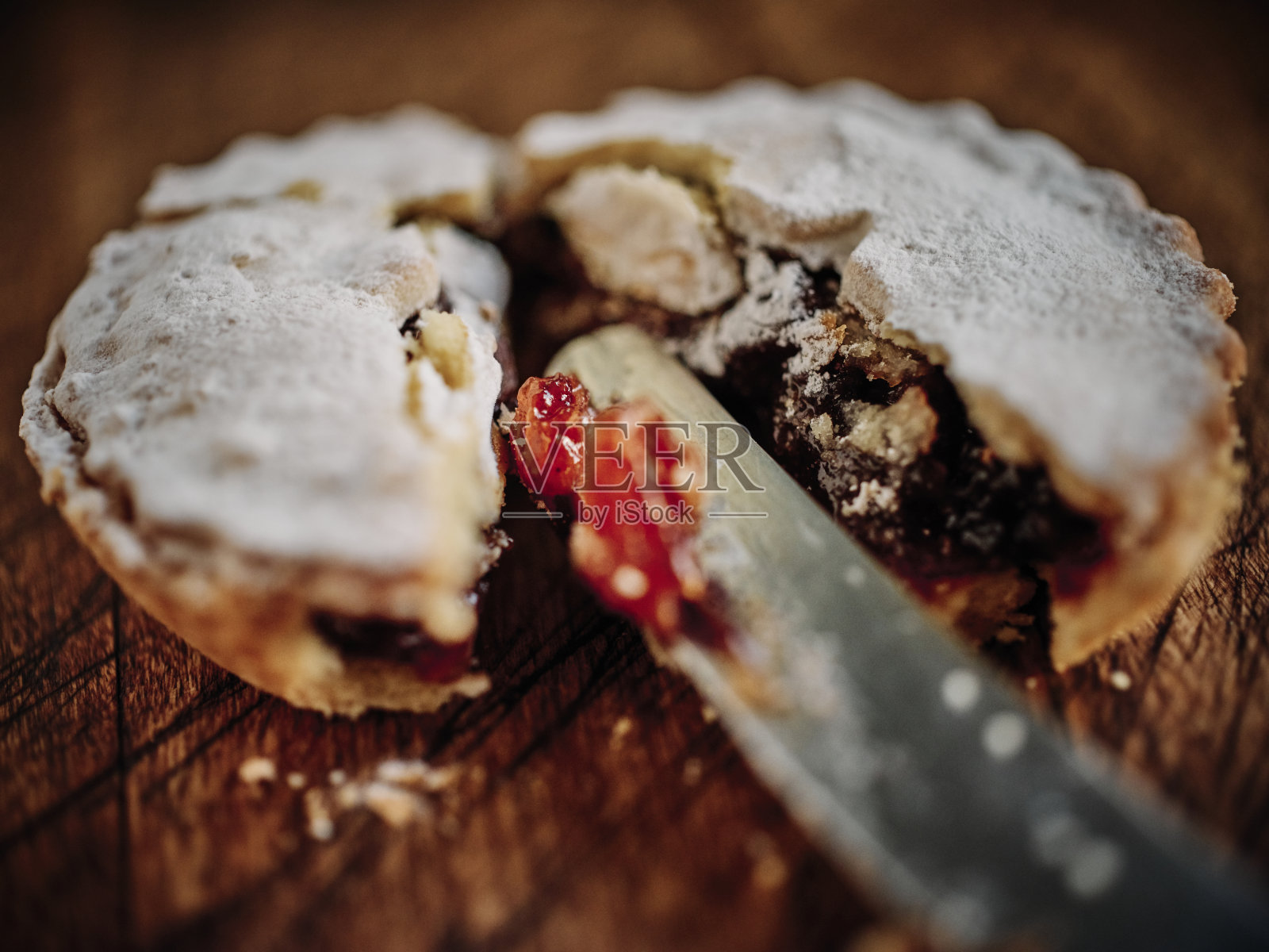一个切开的肉馅饼靠近一个深色的木头表面。照片摄影图片