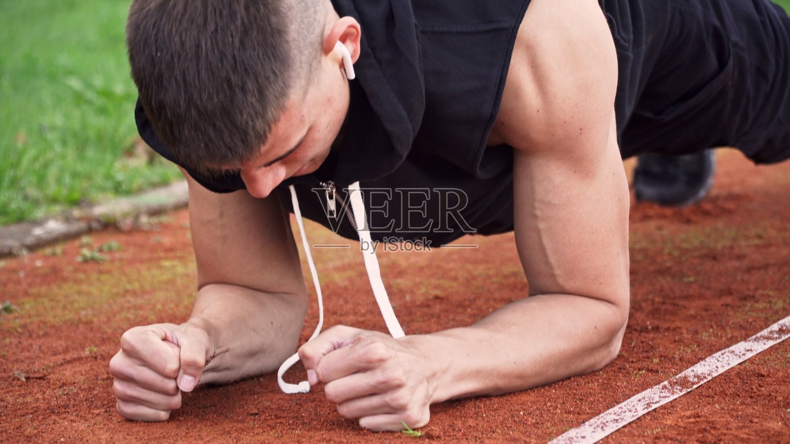 年轻的健康男子做平板支撑运动在户外晨跑跑道照片摄影图片