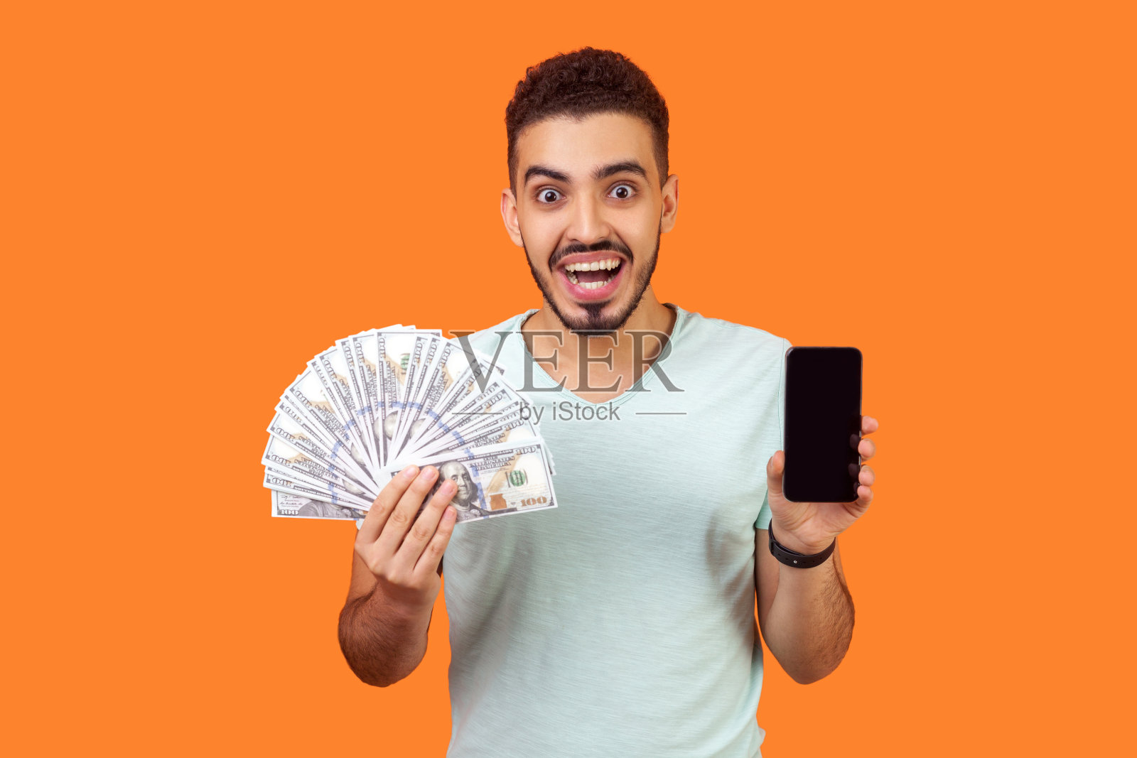 在线支付：手持现金和手机的快乐男人照片摄影图片