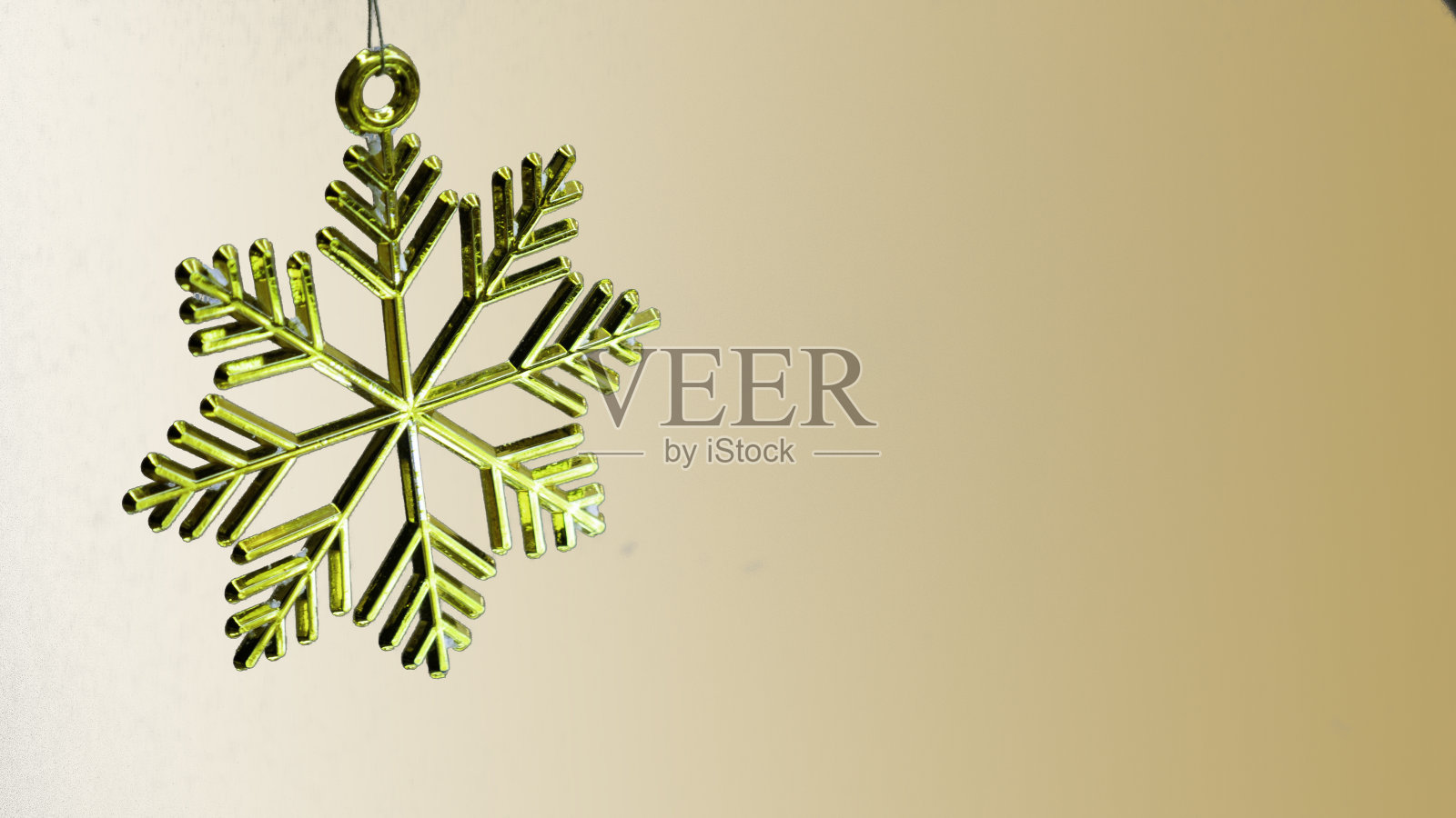 金色背景上的金色塑料雪花装饰。照片摄影图片