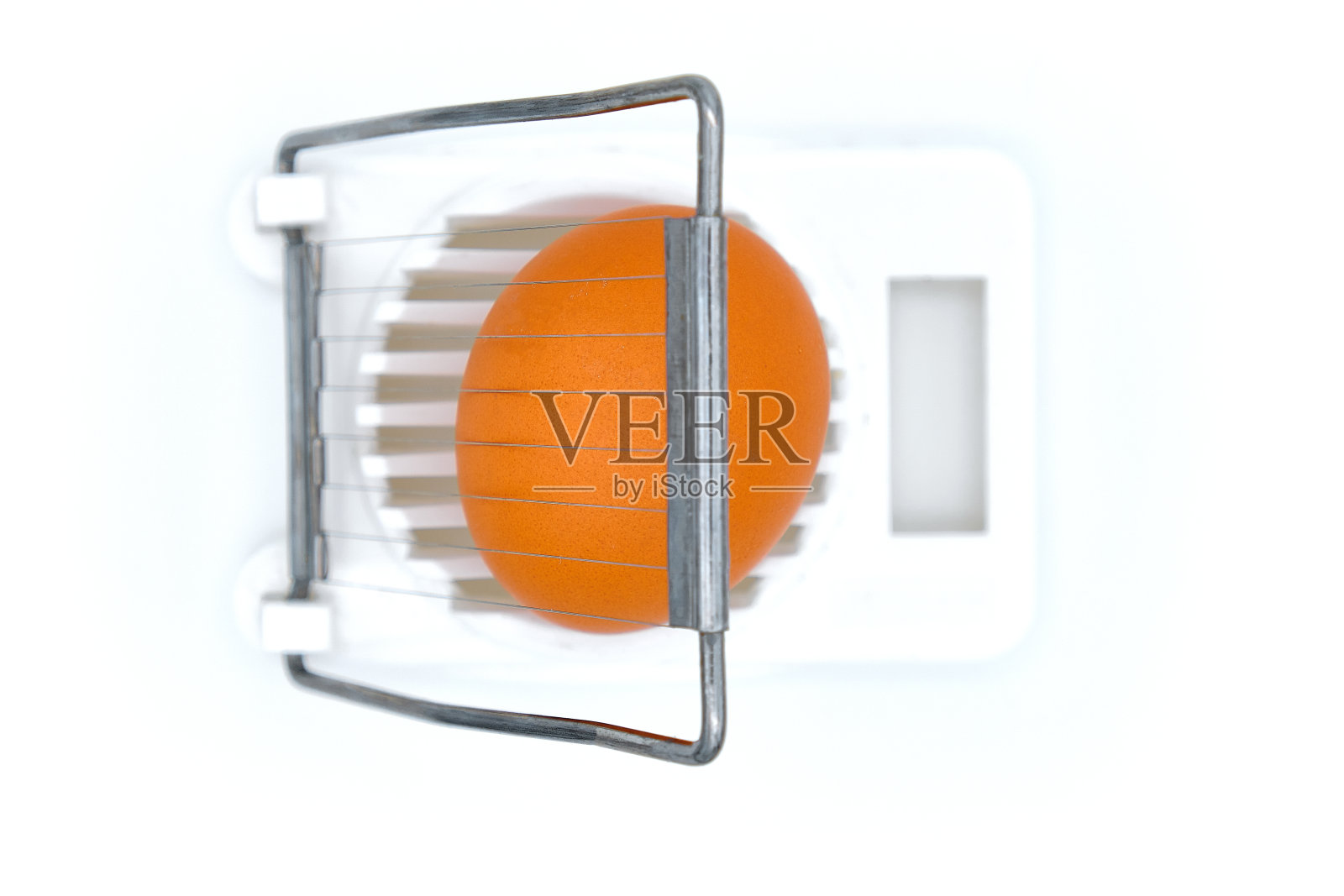 研磨鸡蛋的厨房设备。白色背景隔离。蛋切器里的粗蛋，俯视图。照片摄影图片