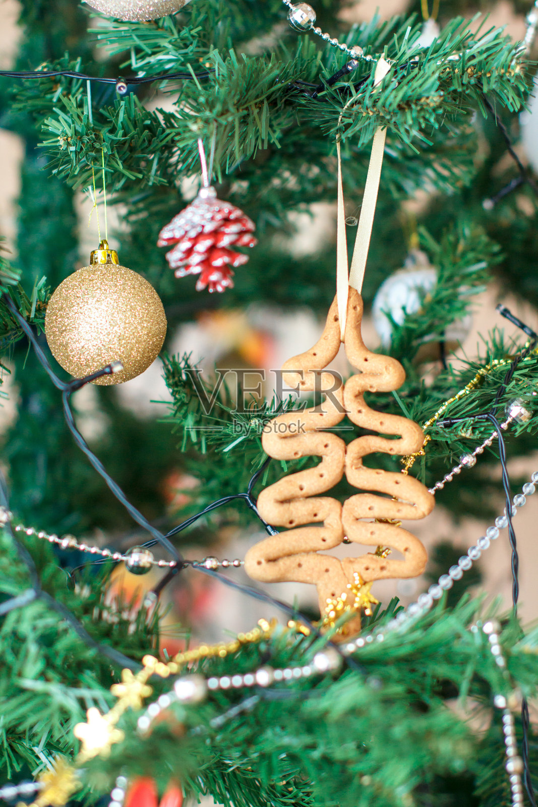 用生面团做成的自制圣诞树玩具挂在树枝上。照片摄影图片