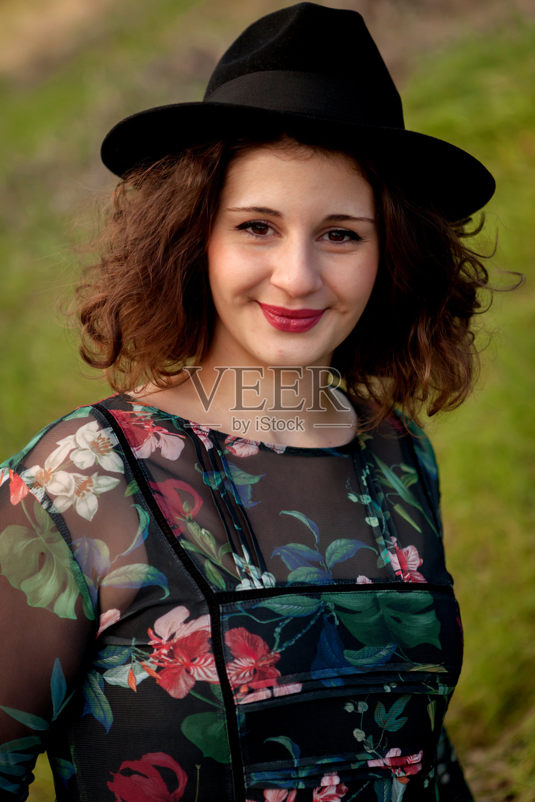 漂亮的女孩穿着花裙，戴着黑帽子照片摄影图片