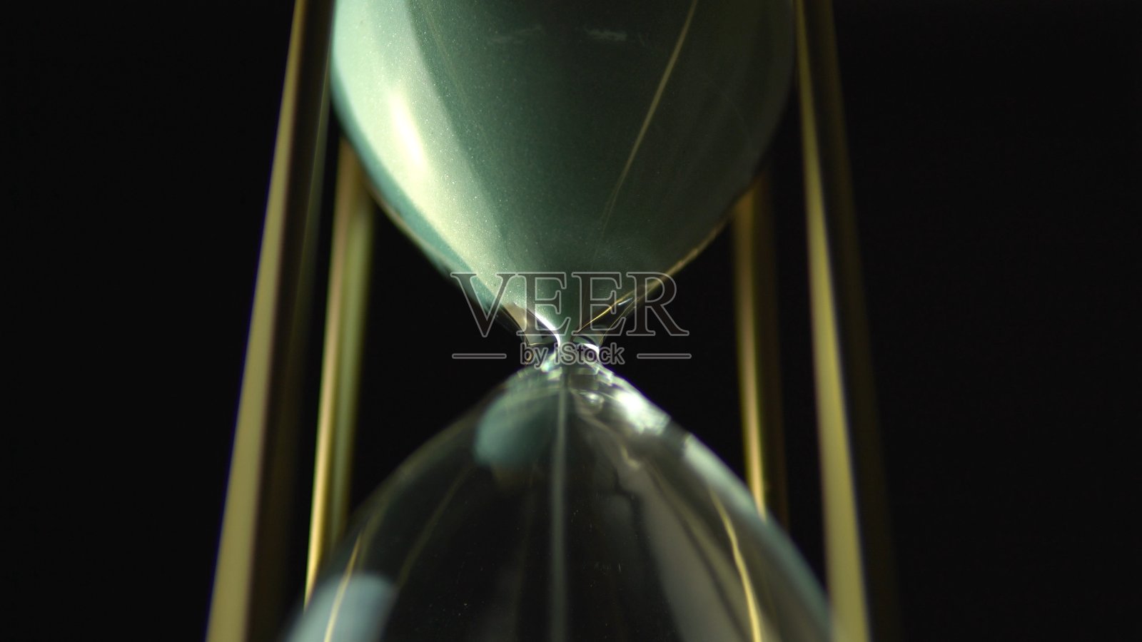 还是沙漏时钟的时间概念。古老的黄金金属框架绿色沙子时钟倒计时在黑暗的背景。关闭了。照片摄影图片