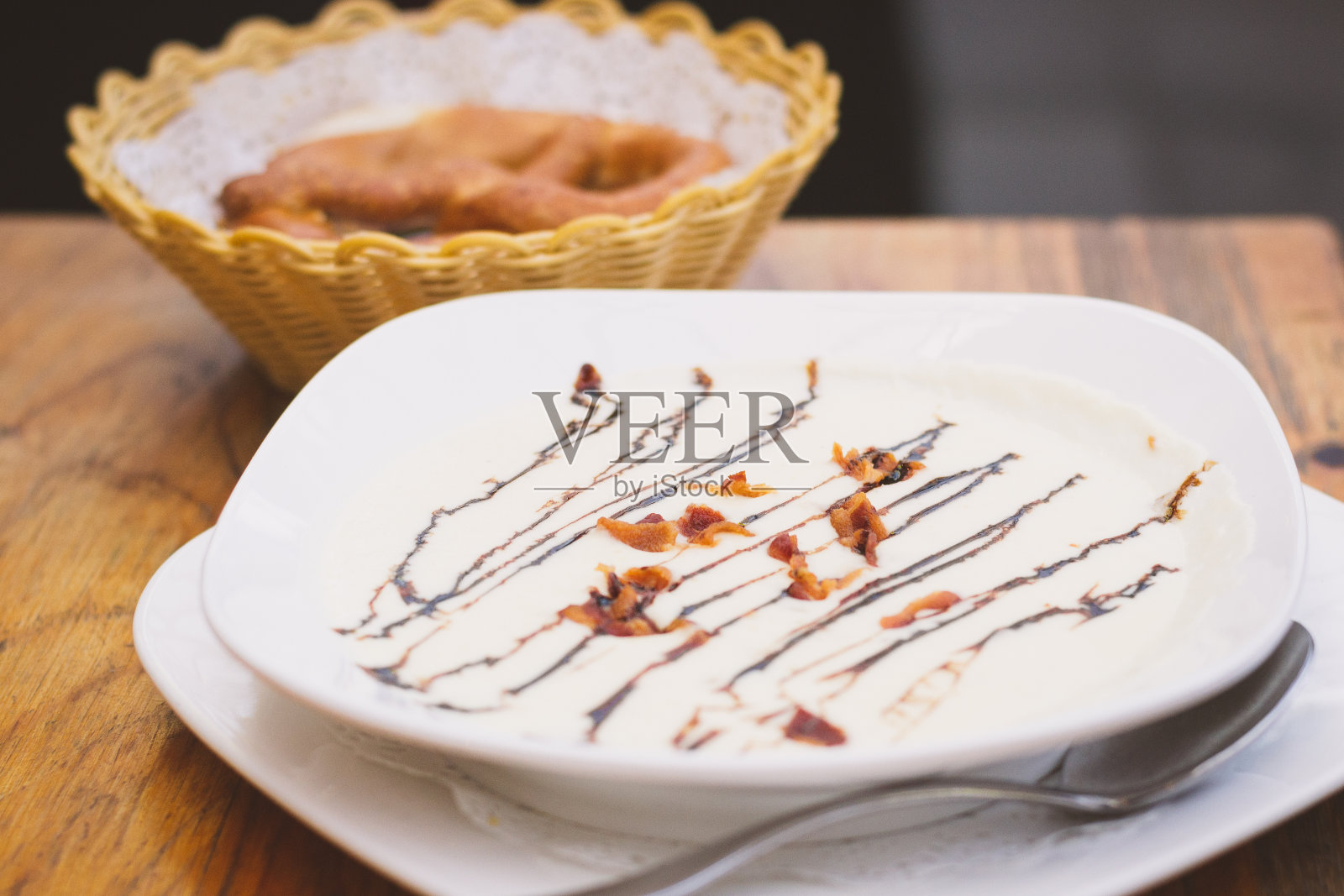 德国风味的奶油土豆汤，配上新鲜的香草和香脆的培根片，椒盐卷饼和黄油照片摄影图片