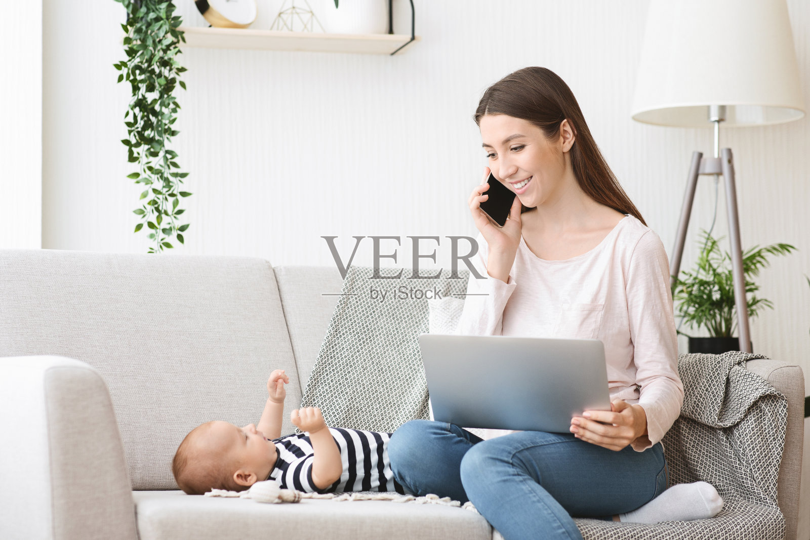 在家用笔记本电脑工作，同时还要照看孩子的女人照片摄影图片