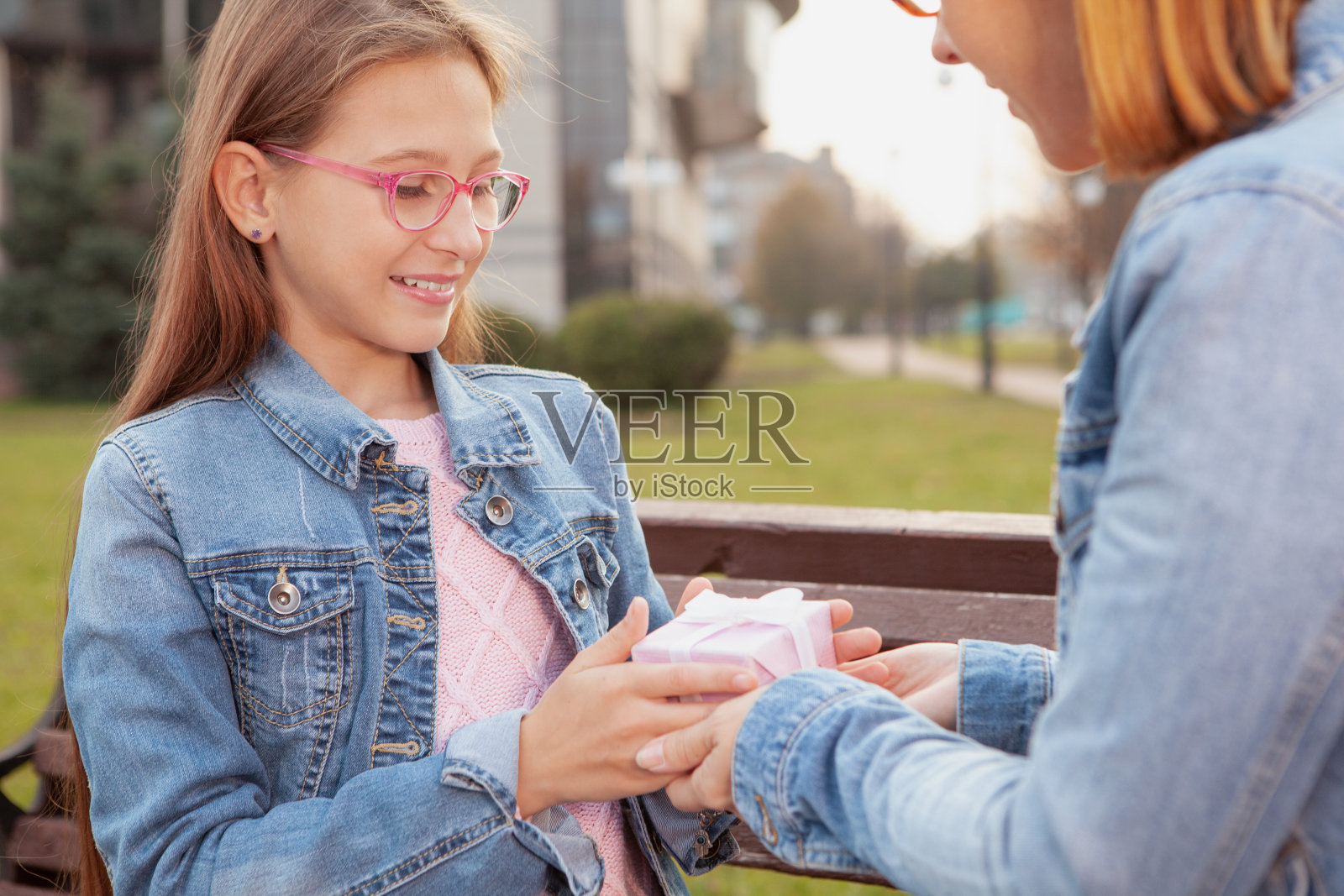 成熟的女人和她可爱的小笑声在城市公园休息照片摄影图片