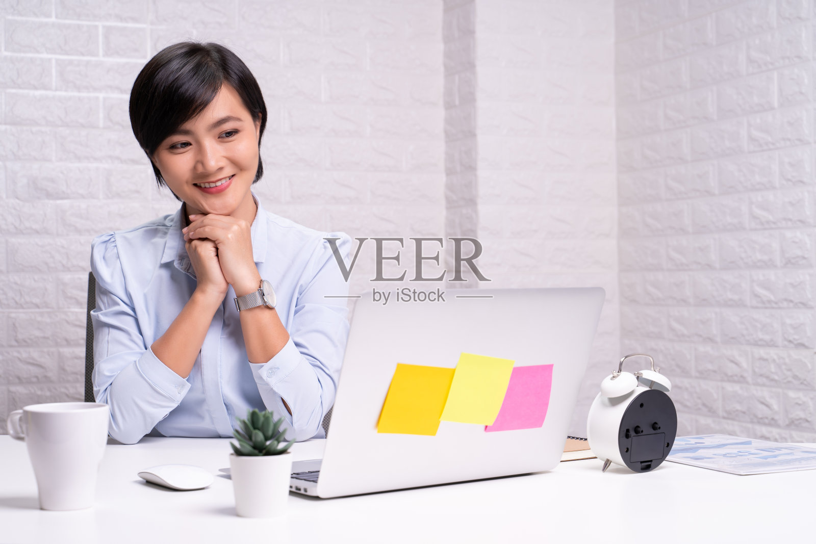 一个快乐的女人坐在家里的办公室里用笔记本电脑工作照片摄影图片