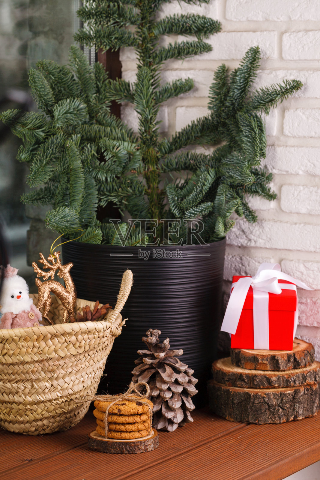 圣诞节的内部。木制的窗台上装饰着一棵圣诞树，一个柳条篮子，里面有玩具、饼干和圣诞树玩具照片摄影图片