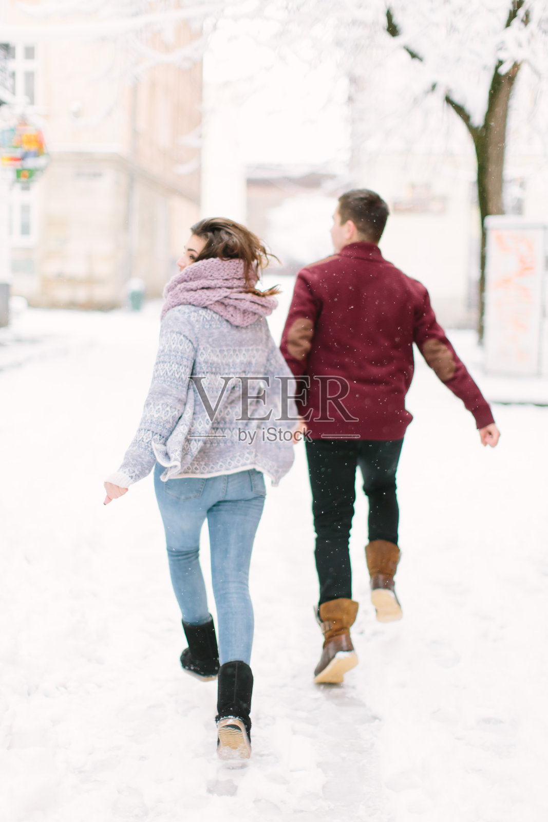 冬季城市的爱。快乐的年轻夫妇在温暖的毛衣在冬天的城市玩。冬天的早晨，圣诞节和节日的概念。照片摄影图片