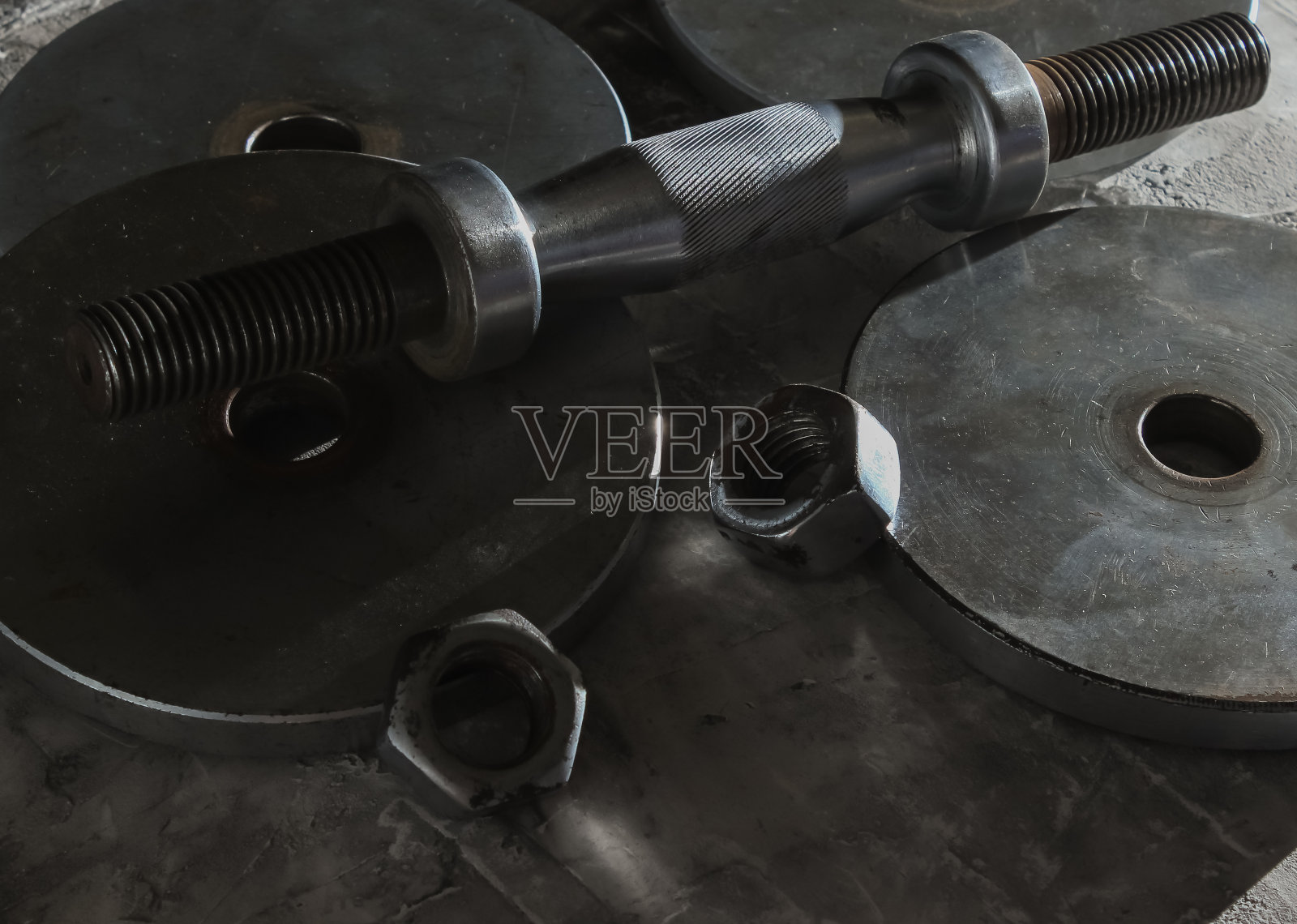 灰色混凝土背景上的一个拆下来的旧哑铃照片摄影图片