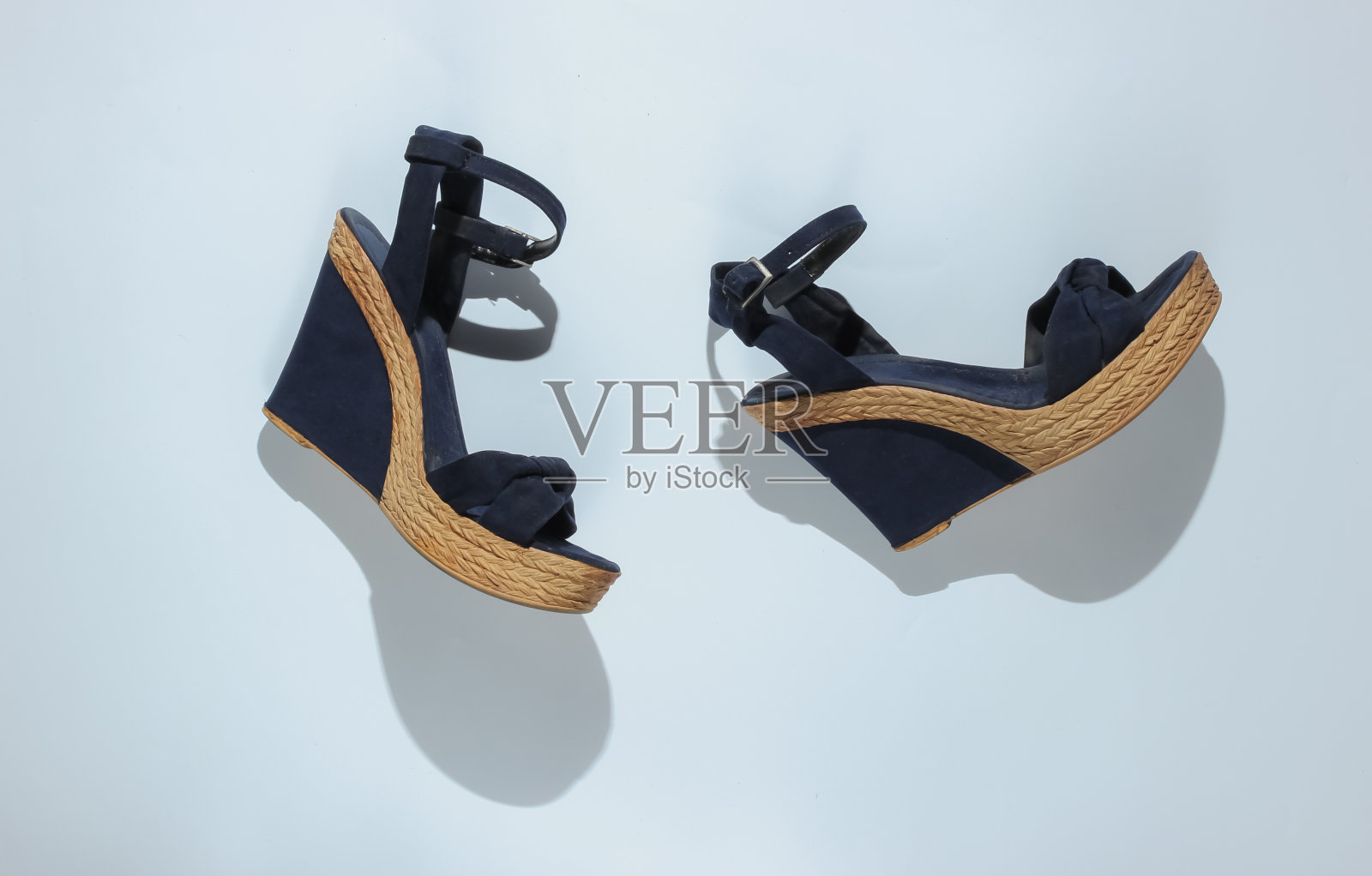 白色背景的平台上穿着时尚的女式凉鞋。夏天的鞋子。影棚拍摄。极简时尚静物画。俯视图照片摄影图片