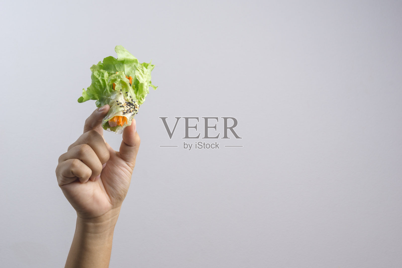 手握水培蔬菜沙拉卷和蟹棒照片摄影图片