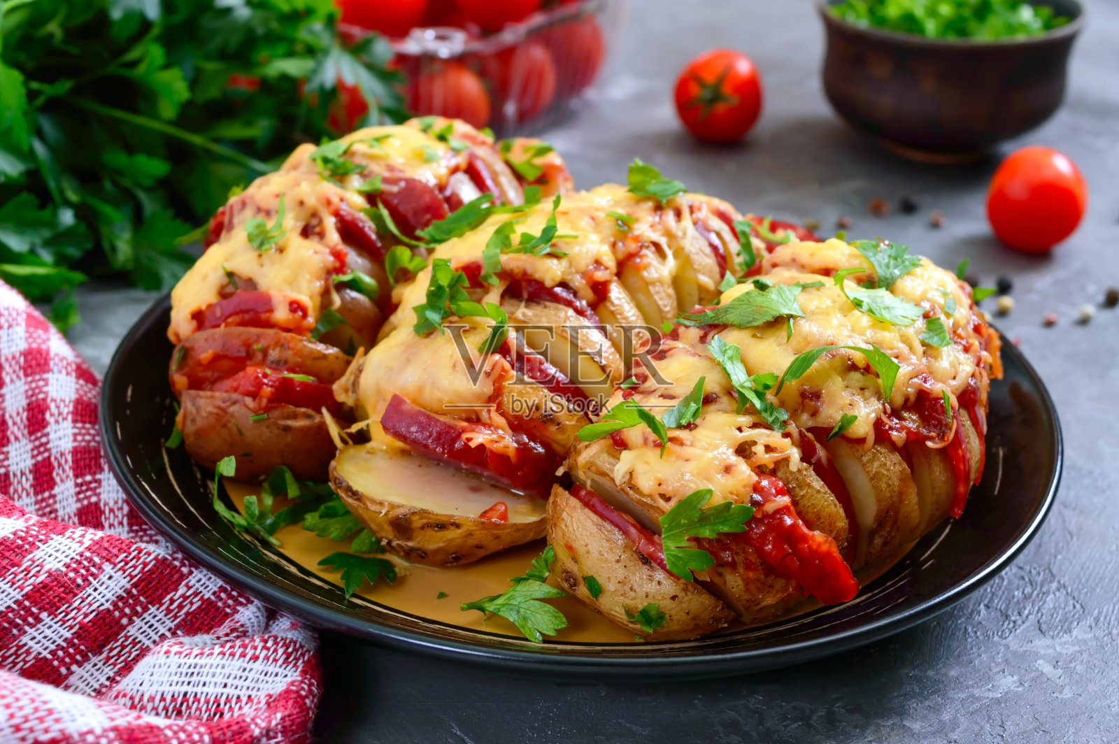 燕尾服土豆泥塞满意大利腊肠，芝士，番茄酱，大蒜和香草。烤土豆切成片，填满馅料。传统的瑞典配方。照片摄影图片