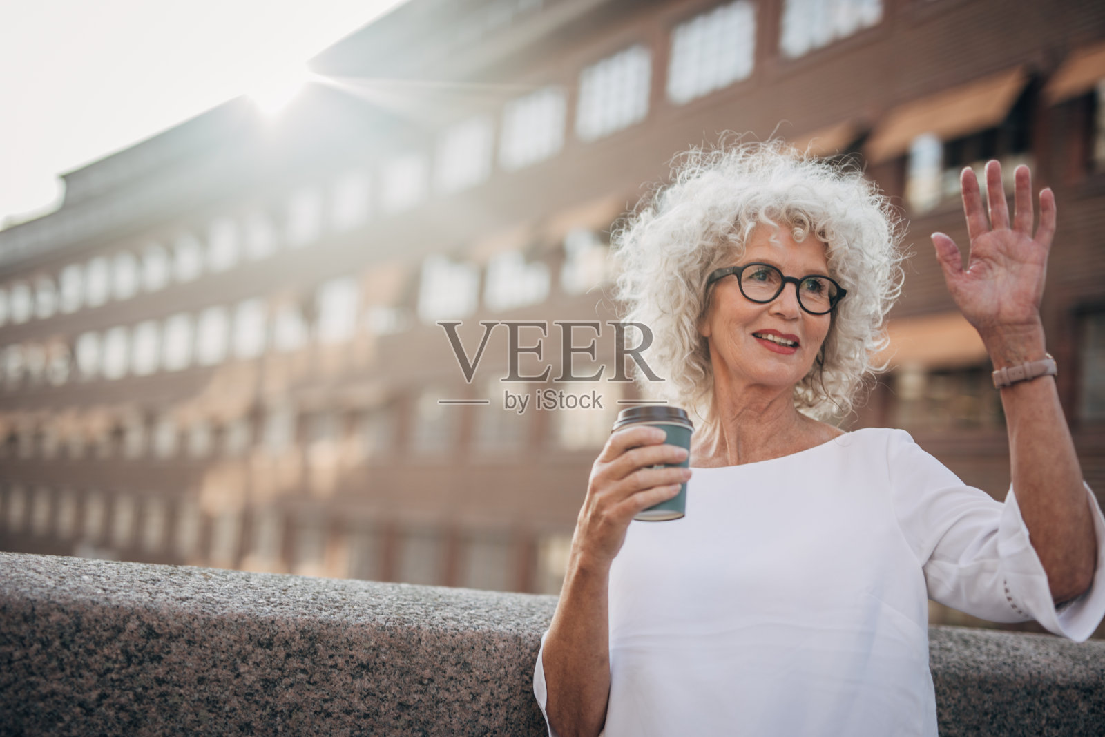 迷人的成熟女士在街上挥手照片摄影图片