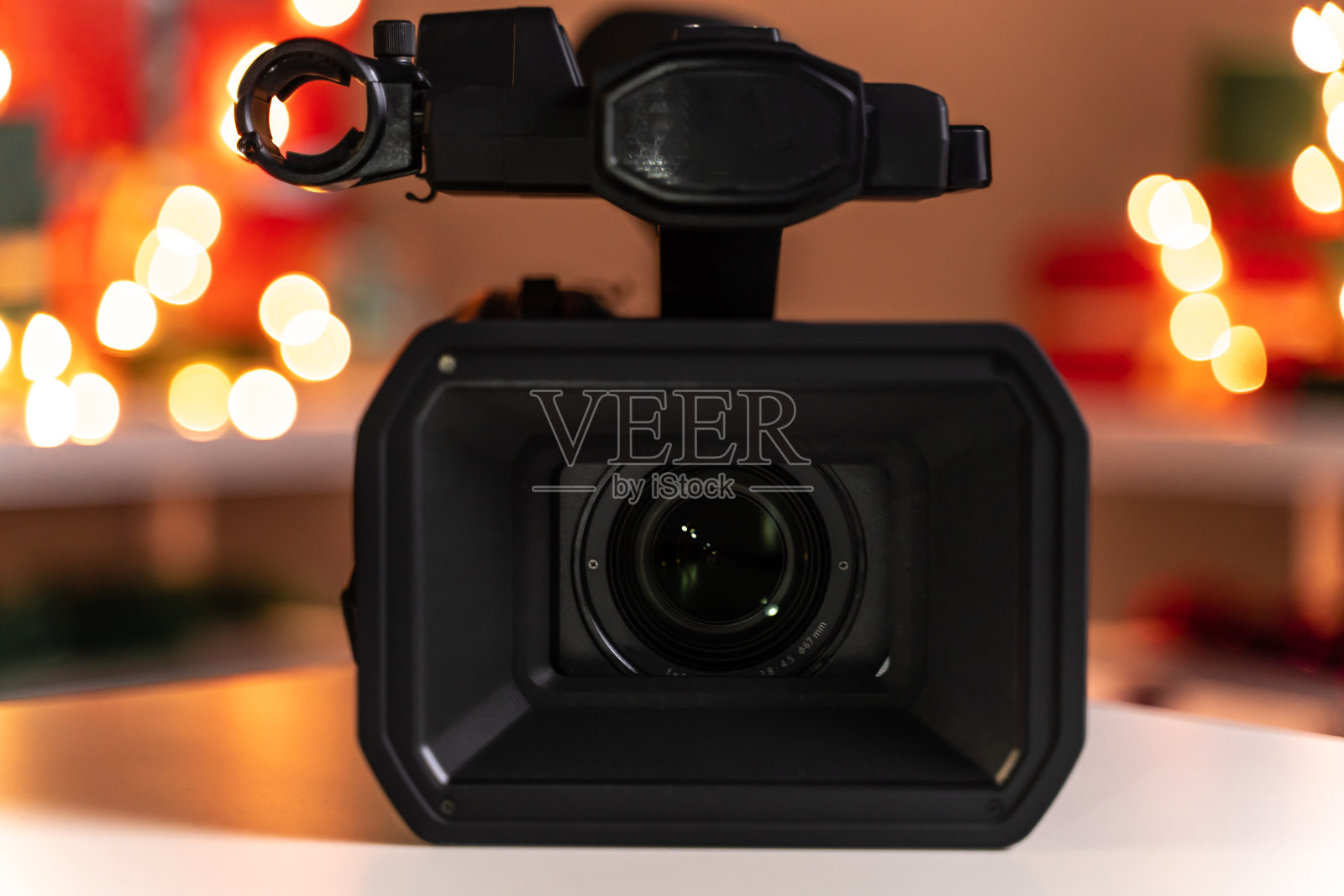 家庭摄像机镜头前圣诞灯和礼物的背景照片摄影图片