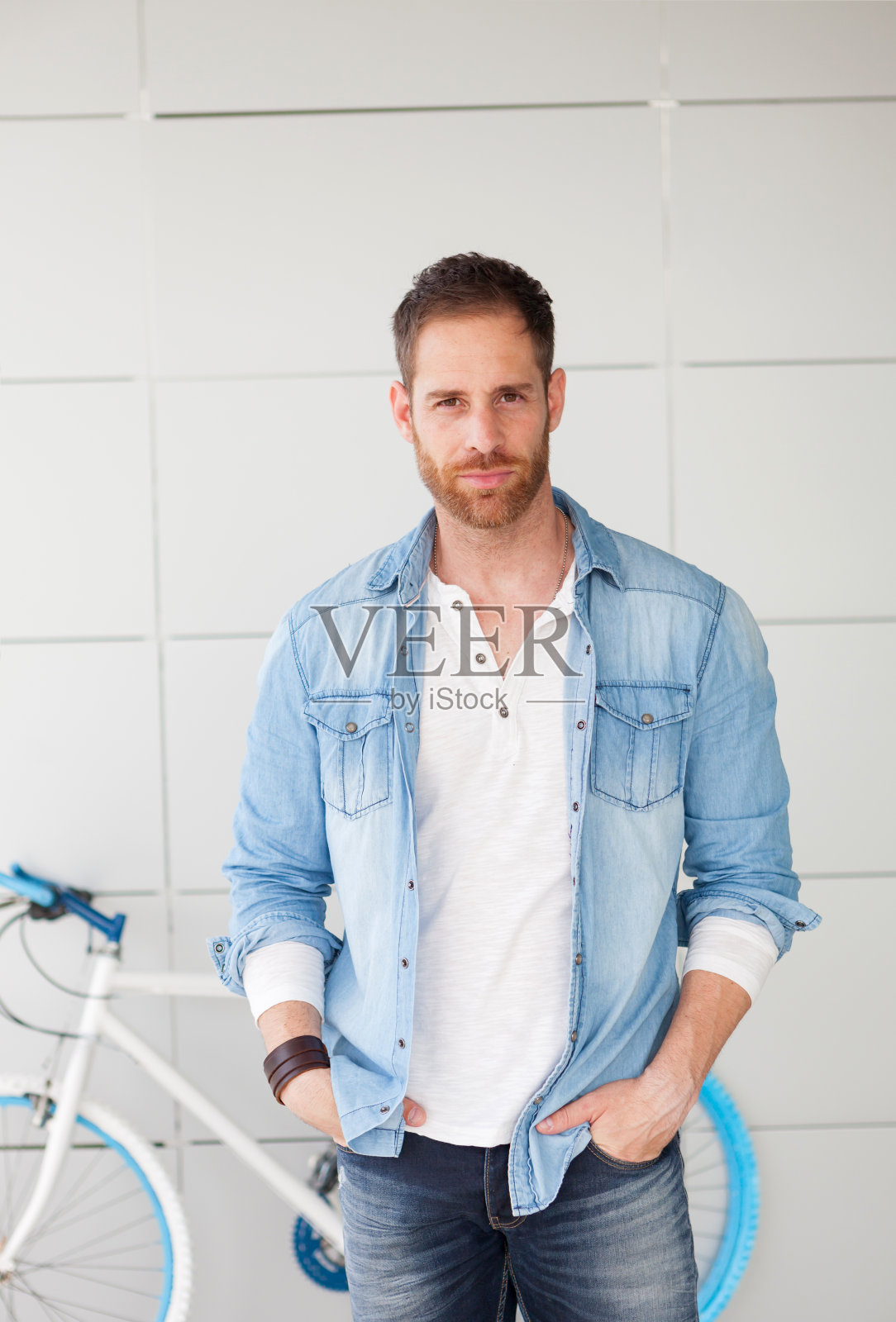 一个随意的人站在他的自行车旁看相机照片摄影图片