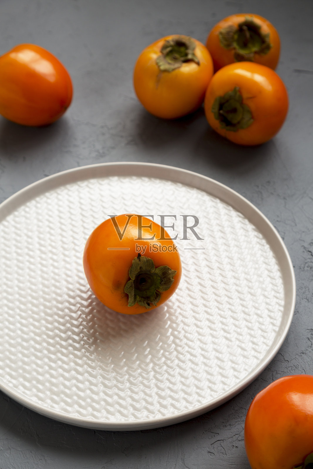 熟透的生鲜柿子表面呈灰色，角度低。照片摄影图片