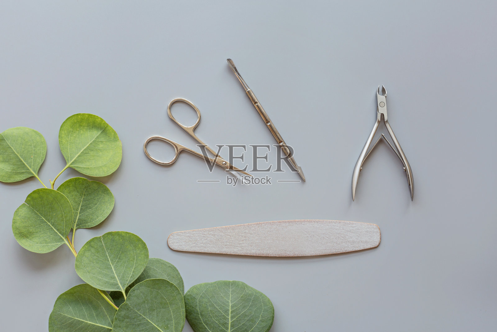 时髦时髦的美甲配件与剪刀，角质层推和桉树花。平铺，俯视图，模拟，模板，头顶照片摄影图片