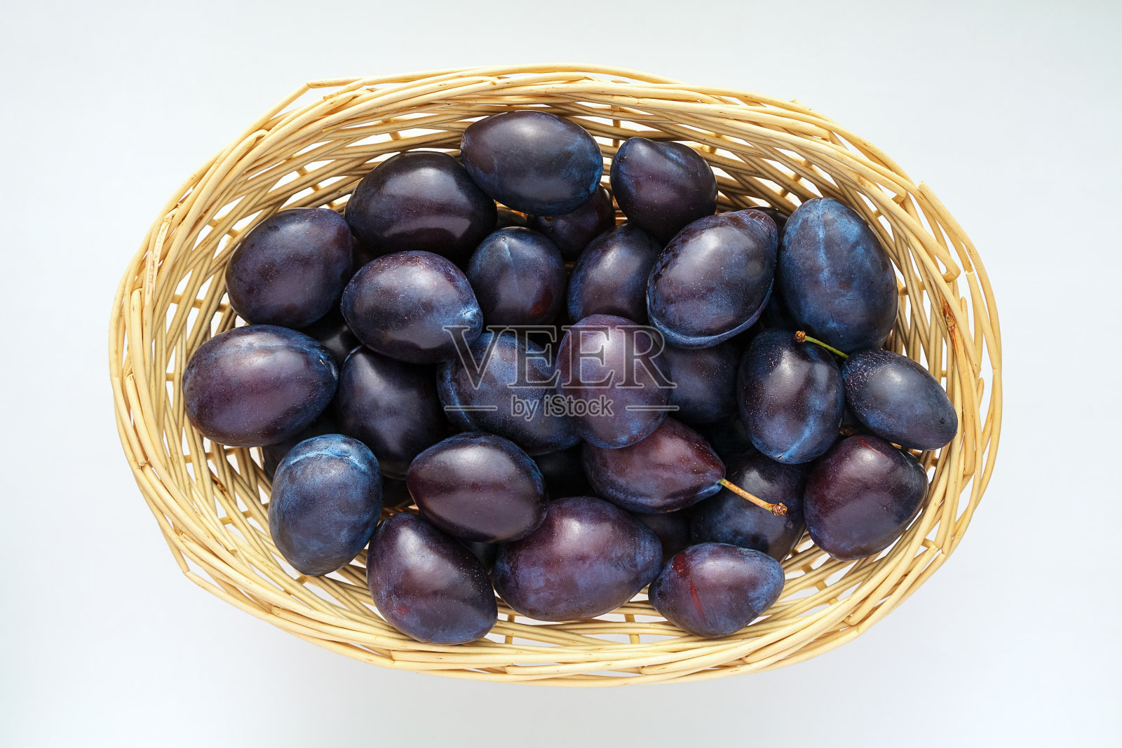 大量的黑李子和水滴在一个秸秆篮子与副本空间特写照片摄影图片