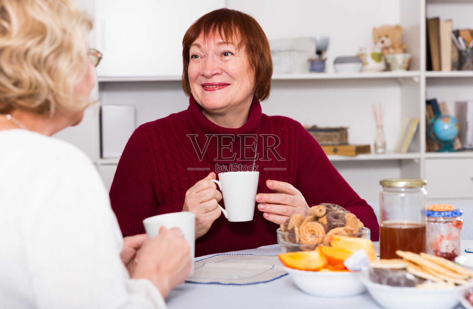 微笑的老妇人与女性朋友喝茶照片摄影图片